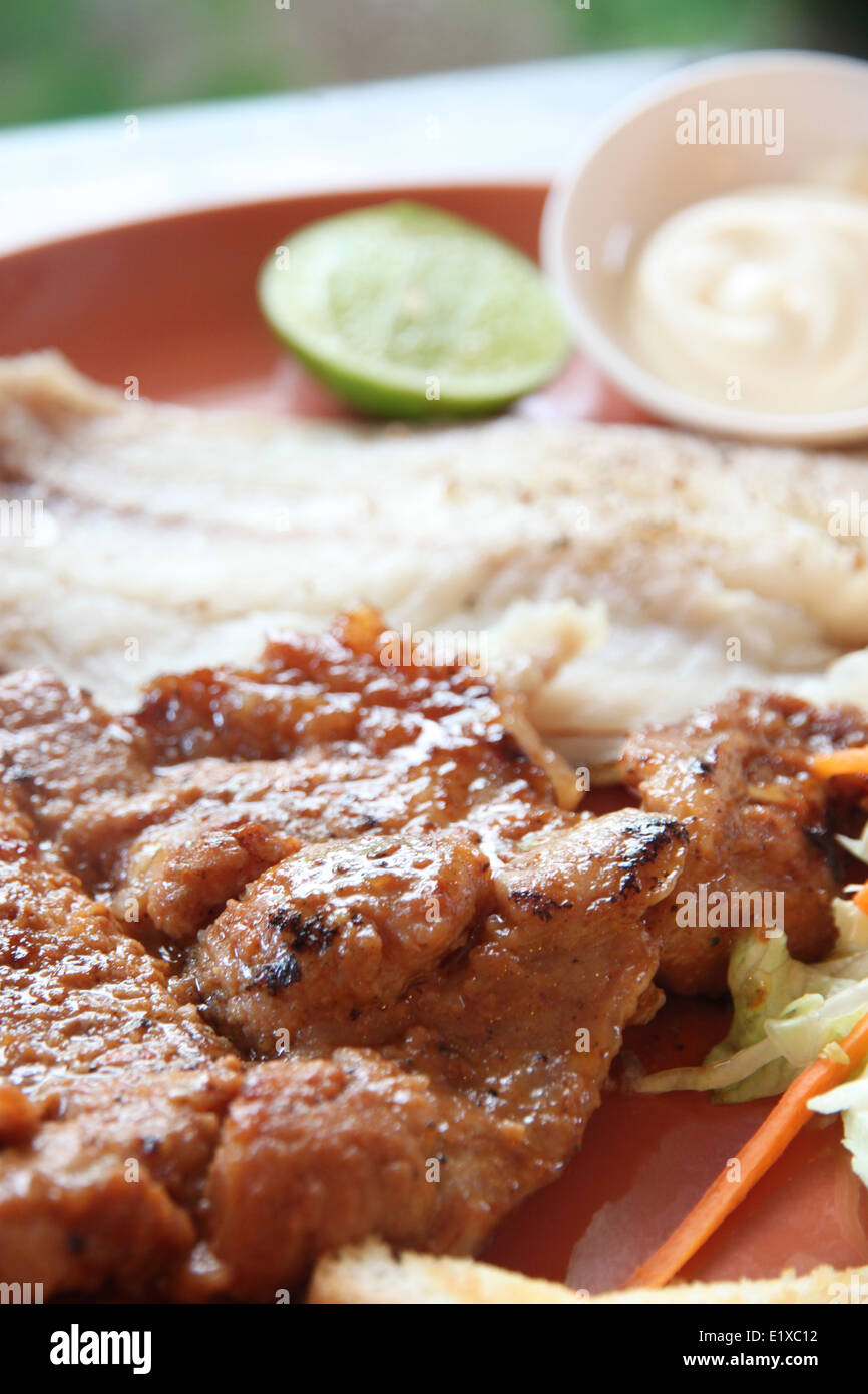 Carne di maiale alla griglia bistecca con patate fritte e toast sul tavolo nel ristorante. Foto Stock