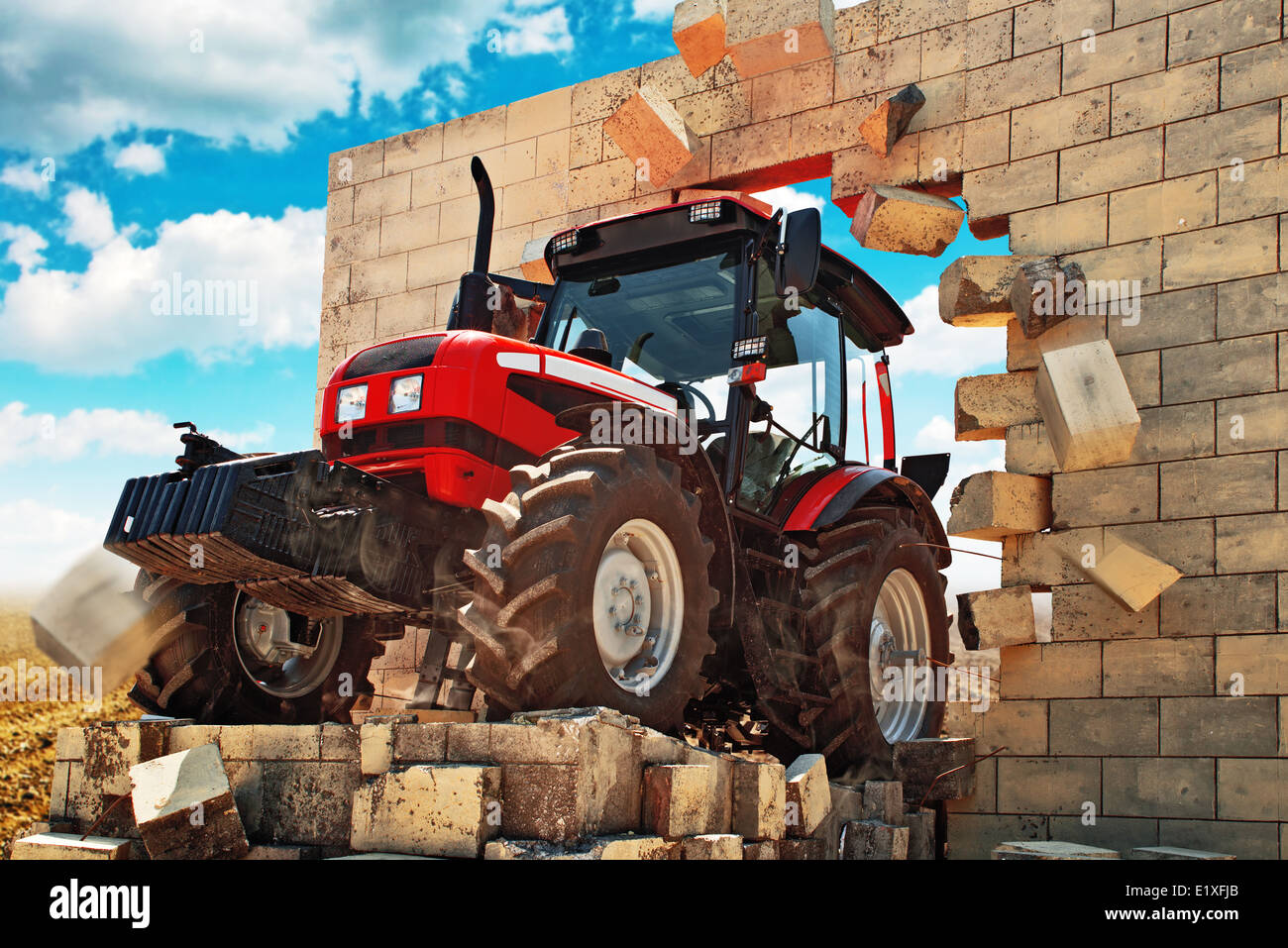 Nuovo trattore, potente lavoro agricolo di rottura della macchina attraverso la parete. Superando tutti gli ostacoli nel settore agricolo. Foto Stock