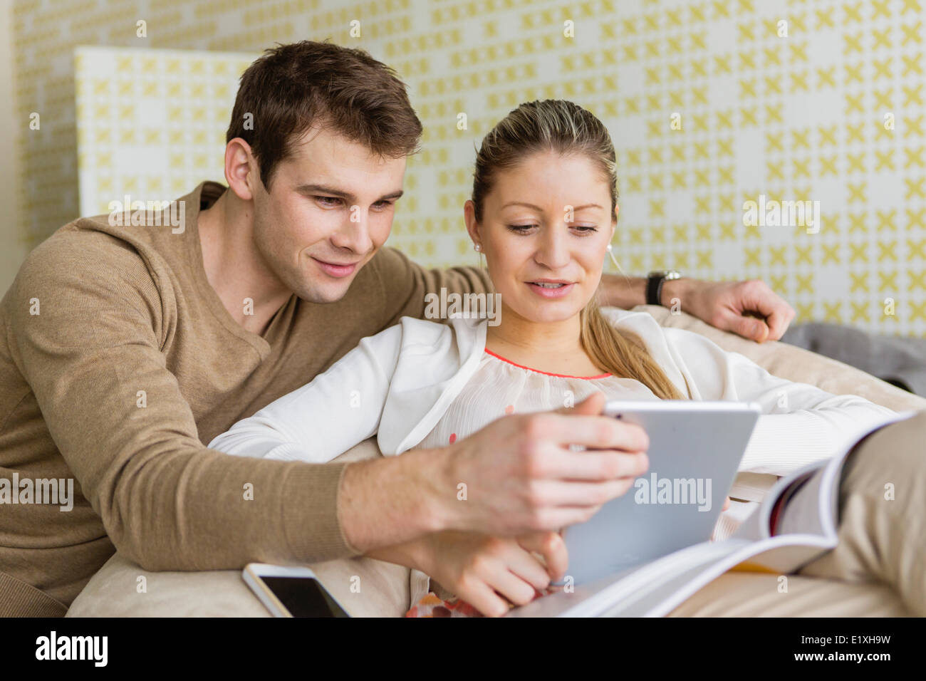 Felice coppia giovane utilizzando tablet PC a casa Foto Stock