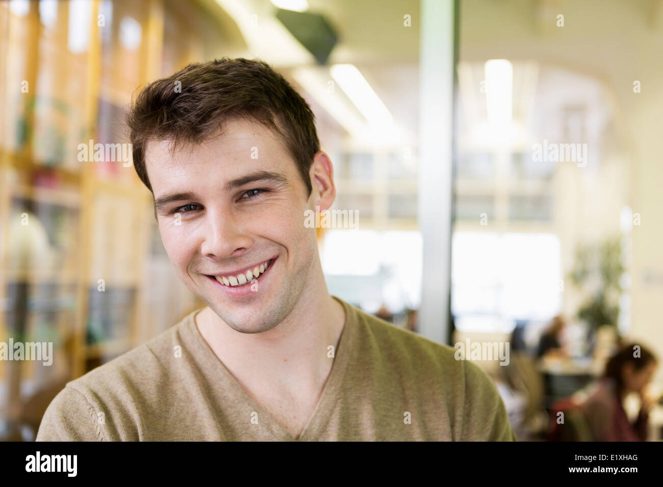 Ritratto di bel giovane imprenditore sorridente in ufficio Foto Stock