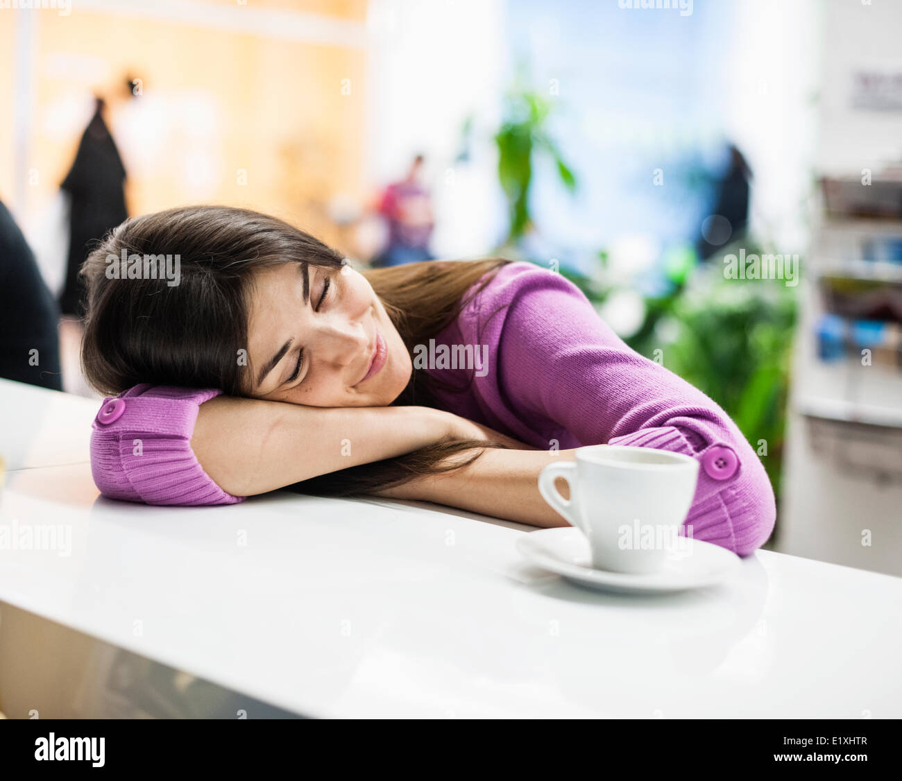 Giovane imprenditrice a dormire la scrivania in ufficio Foto Stock
