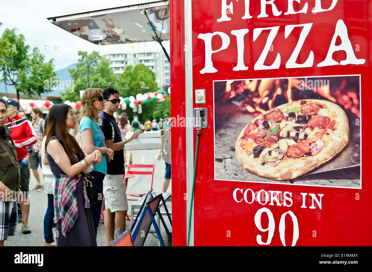 Le persone in attesa di Whistler pizza al forno a legna dal cibo carrello su unità commerciali durante la giornata italiana a Vancouver 2014. Foto Stock