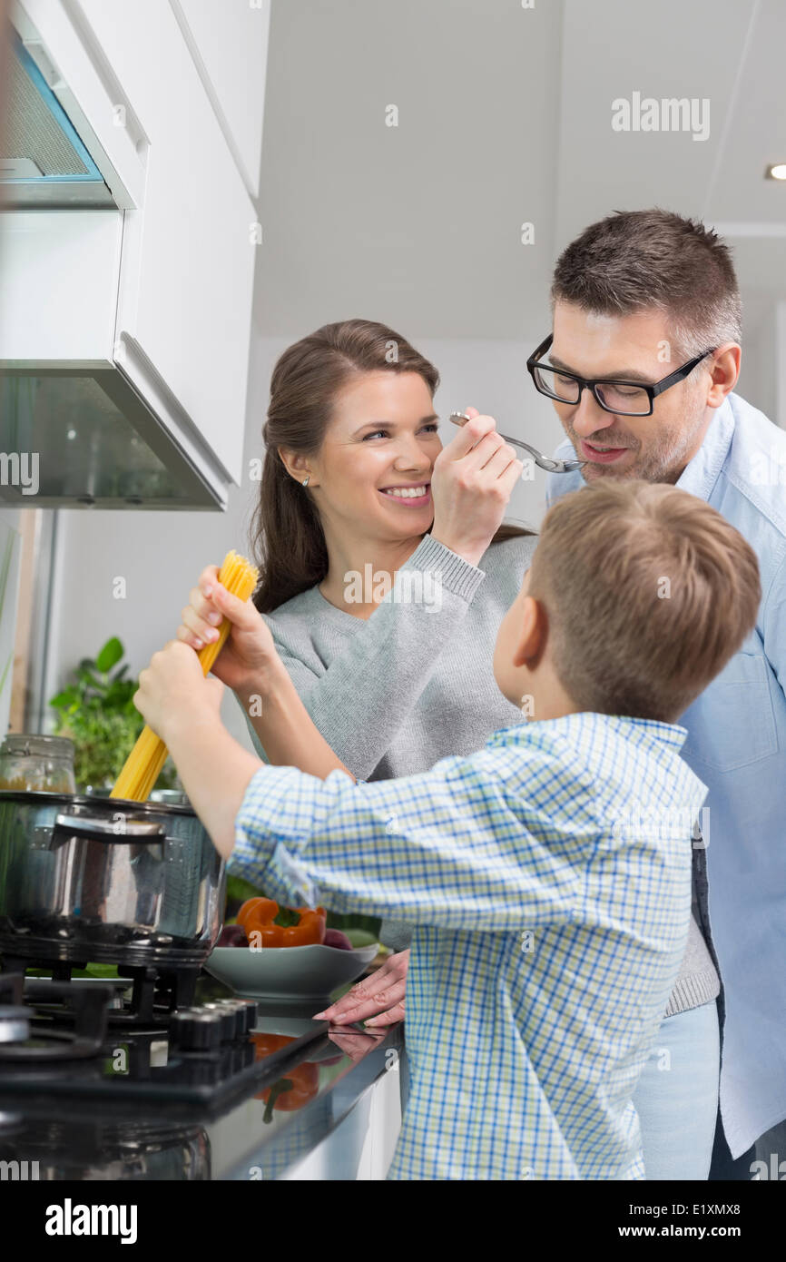 La famiglia felice preparare spaghetti in cucina Foto Stock