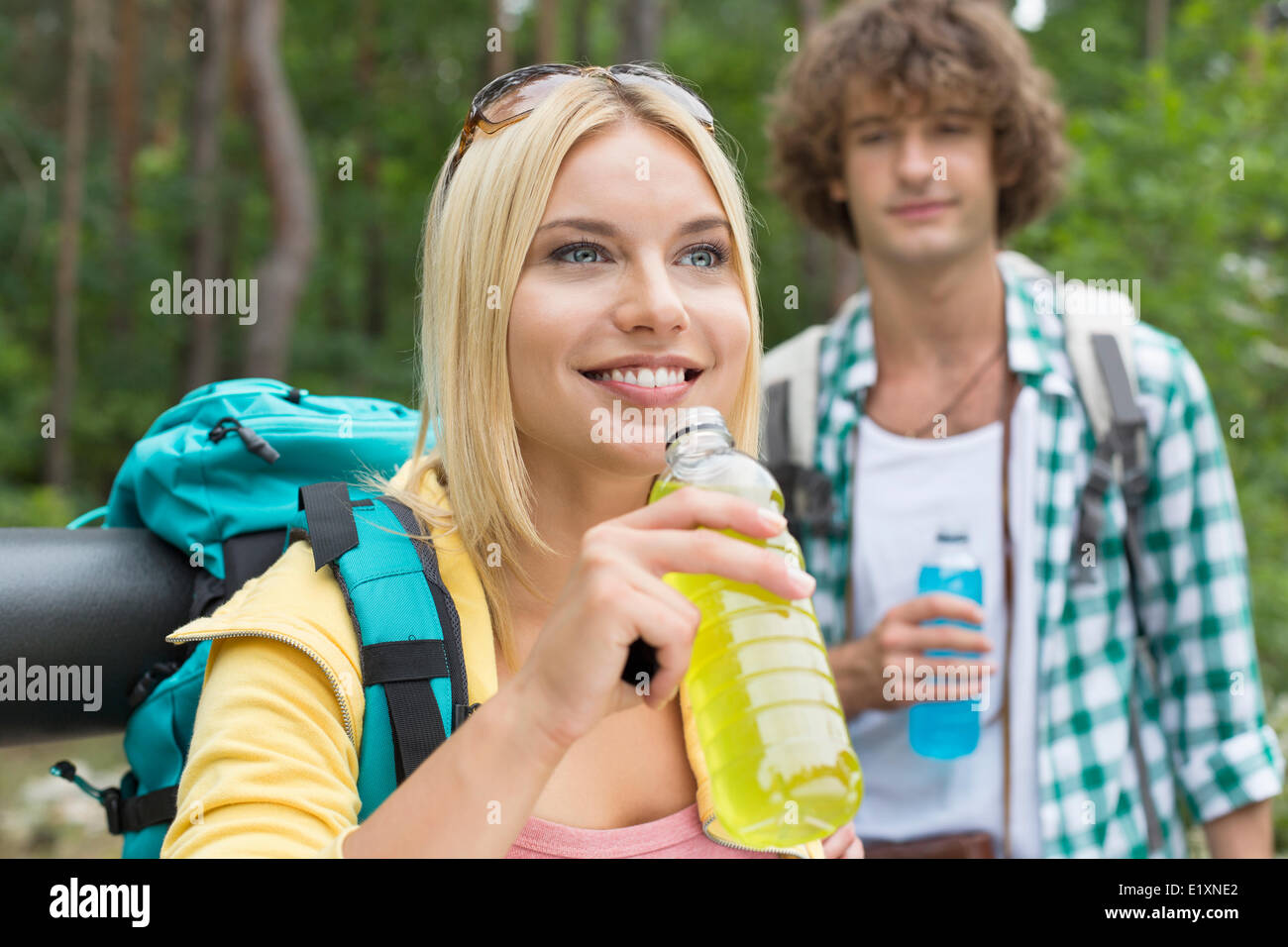 Escursionismo coppia con bevande energetiche in foresta Foto Stock
