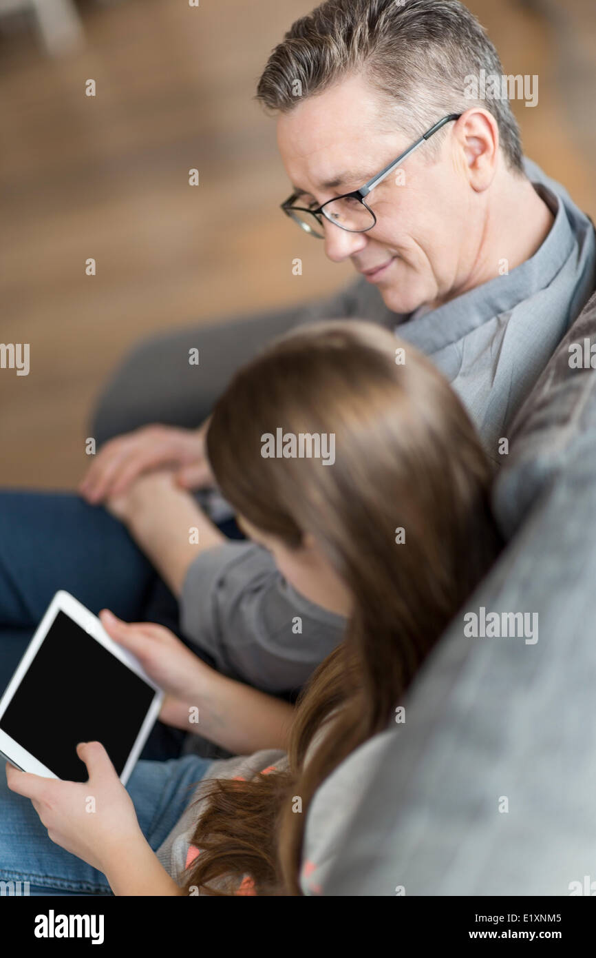 Elevato angolo di visione del padre e figlia con tavoletta digitale in casa Foto Stock