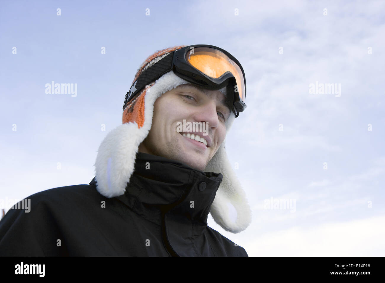 Giovane uomo in occhiali da sci e un cappello invernale Foto Stock