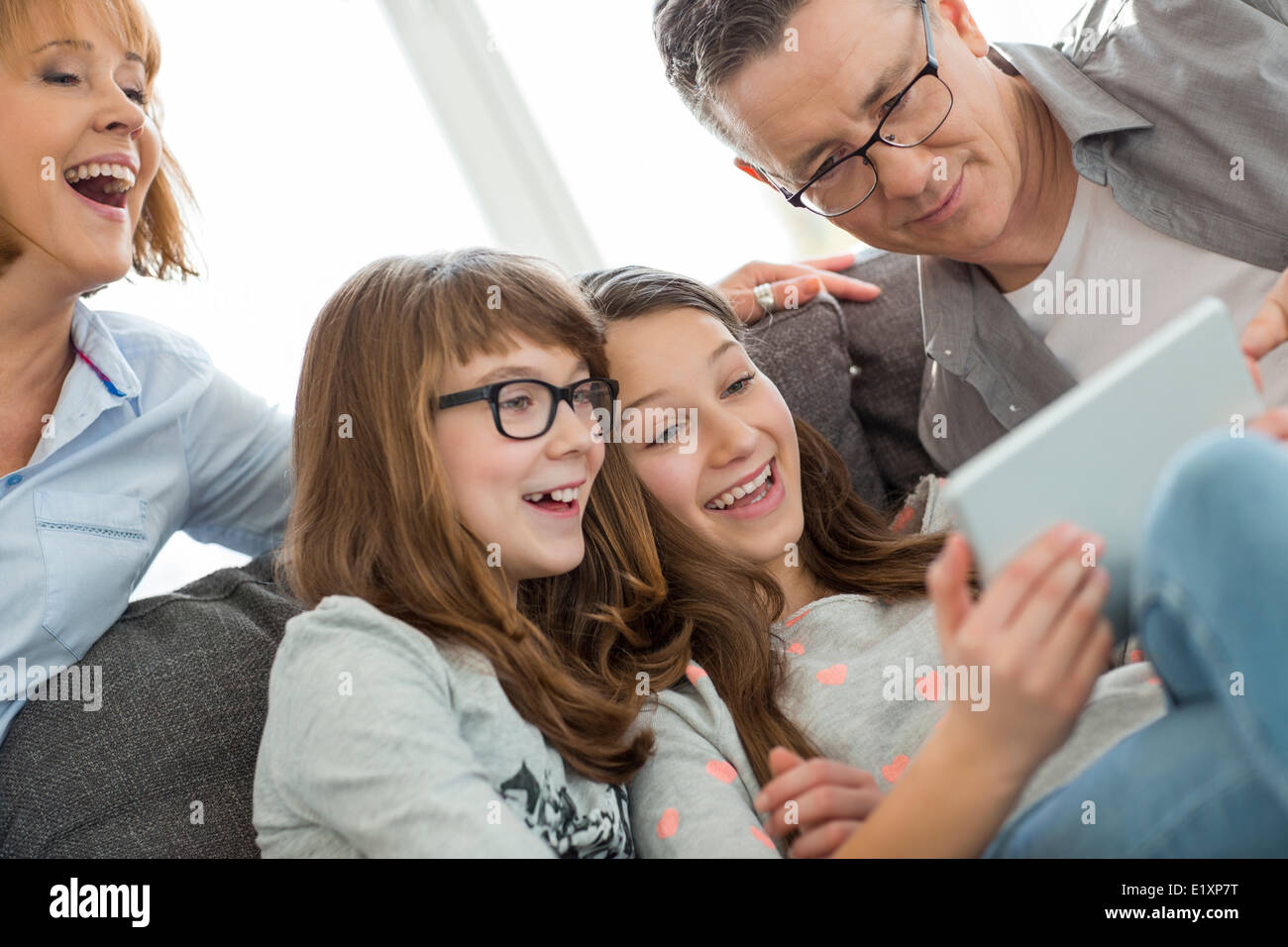 Famiglia allegra utilizzando tablet PC a casa Foto Stock