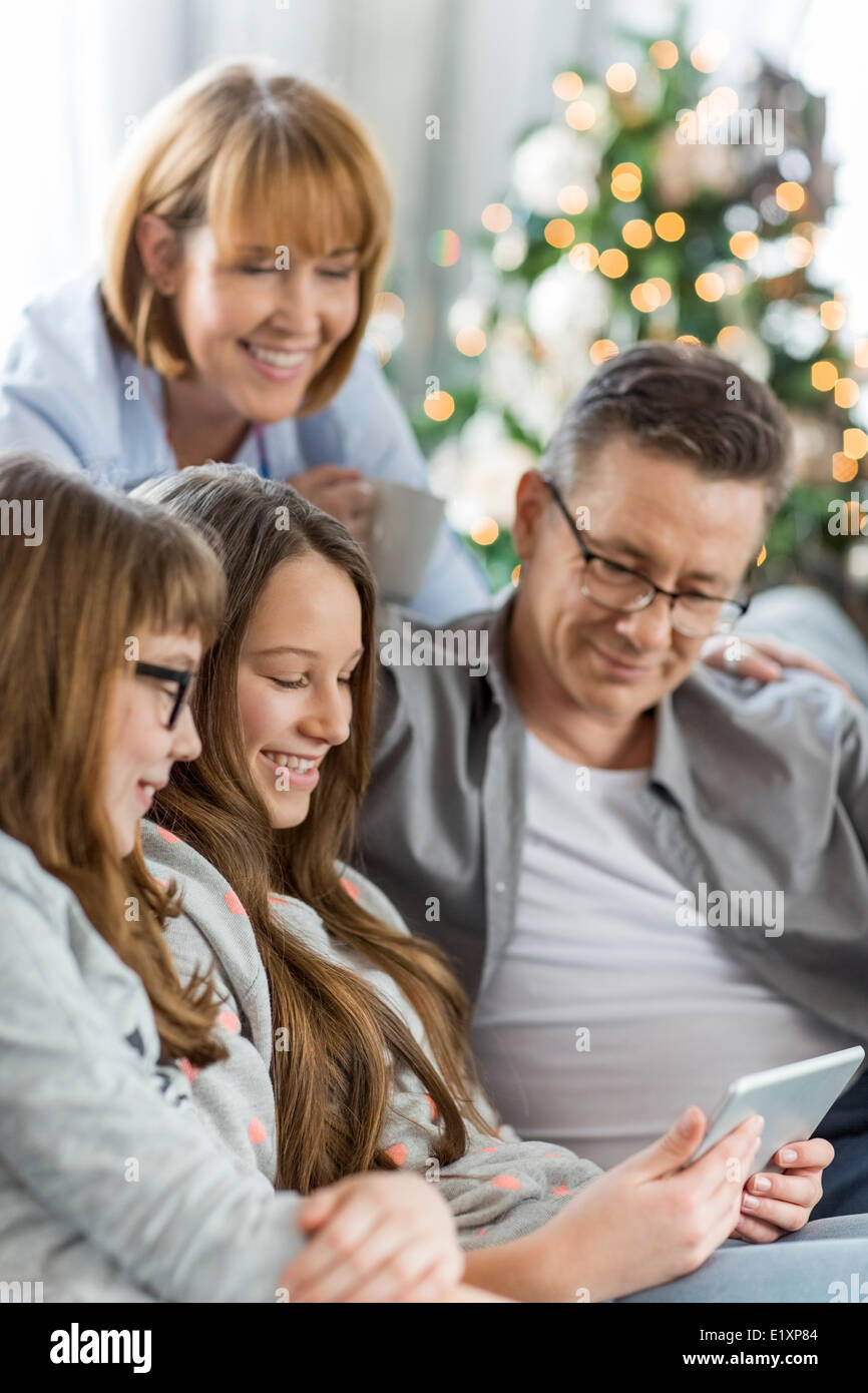 La famiglia tramite tablet PC insieme a casa Foto Stock