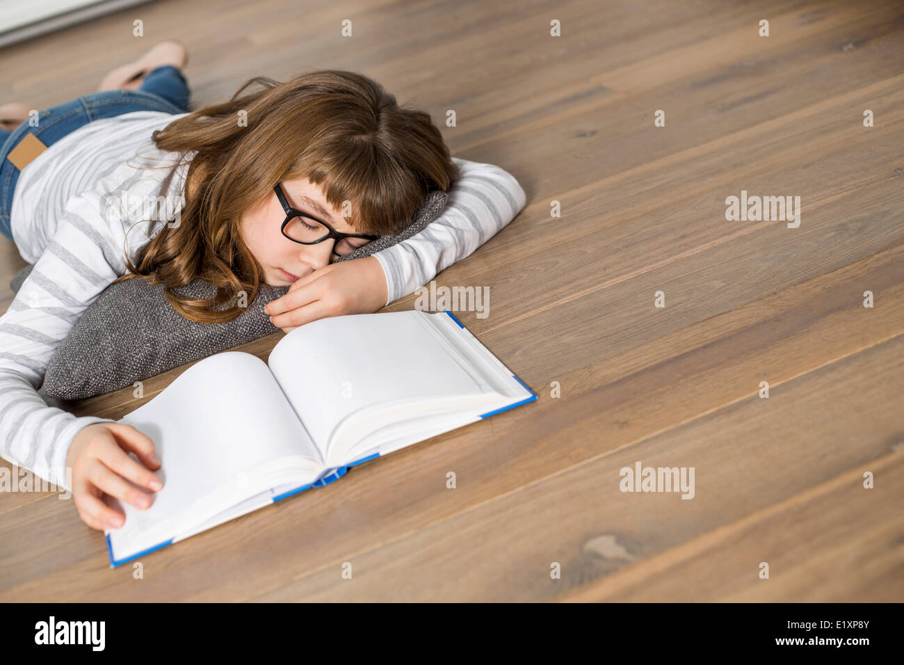 Angolo di Alta Vista della ragazza adolescente dormendo mentre lo studio sul pavimento Foto Stock