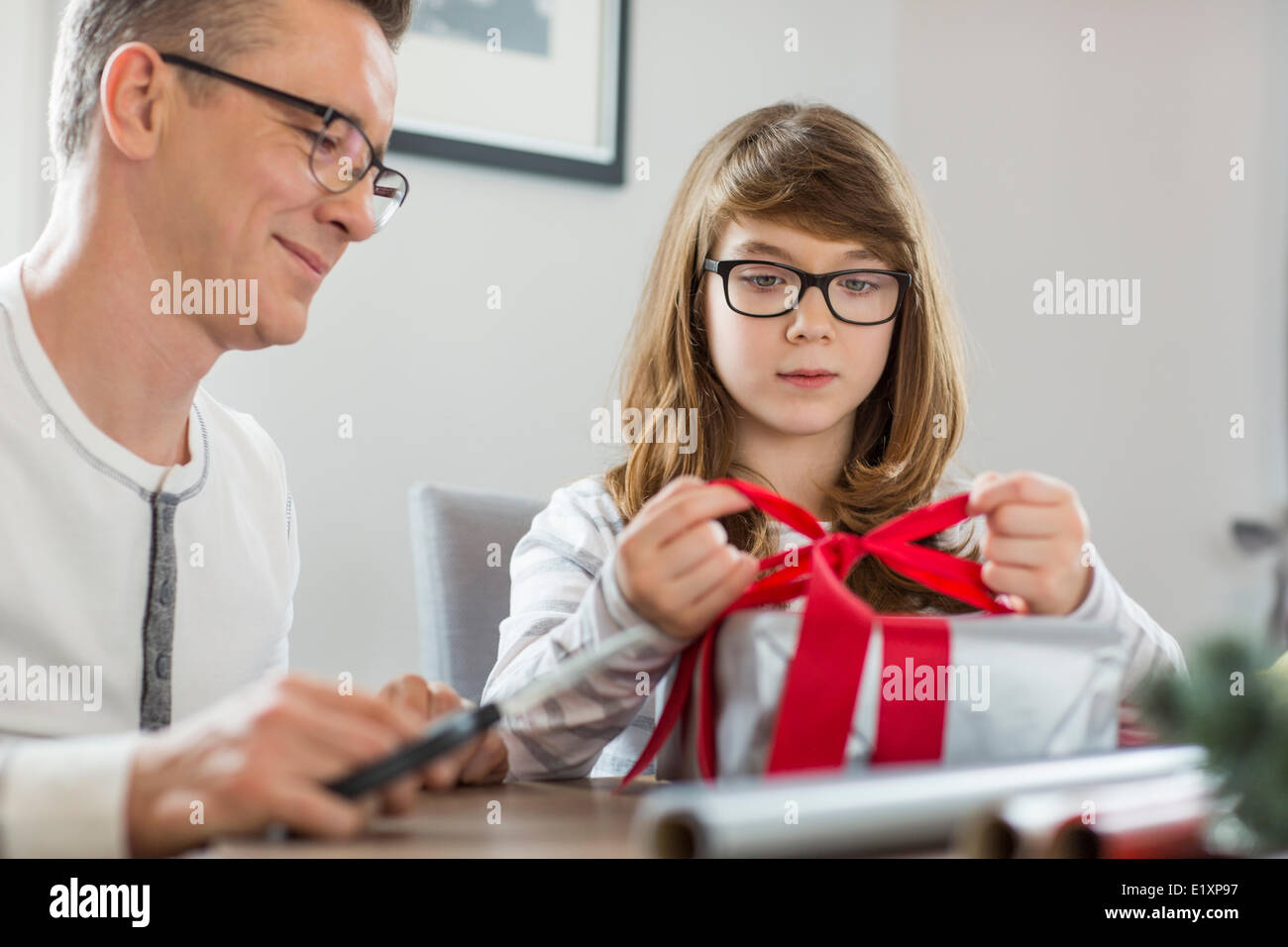 Padre e figlia di Natale di incarto presente a casa Foto Stock