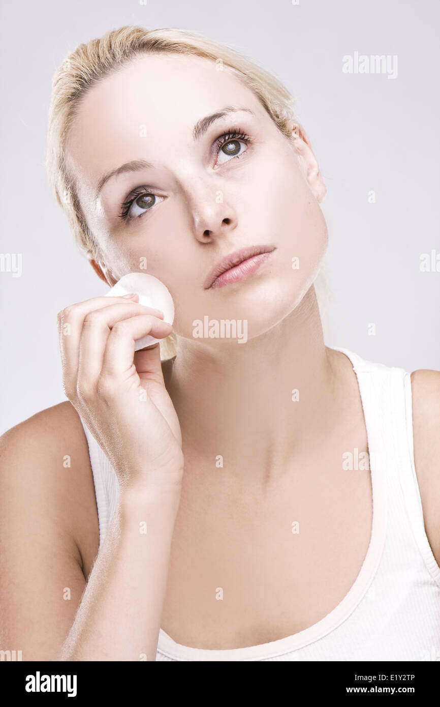 Bella bionda la rimozione di trucco per il viso Foto Stock