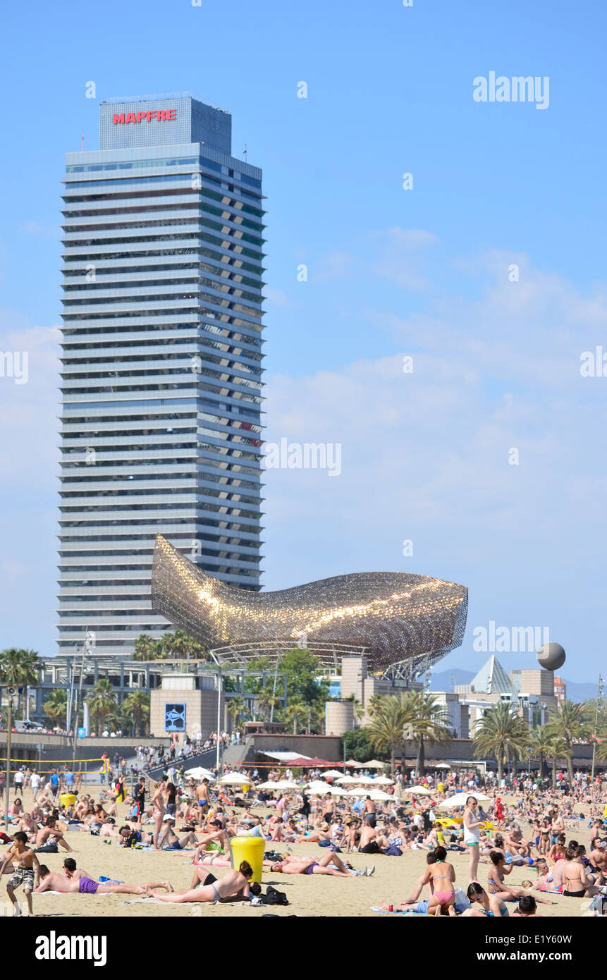 Lucertole da mare a Barceloneta Beach con Frank Gehry's Fish, Peix, scultura e Mapfre edificio a torre. Barcellona, in Catalogna, Spagna. Foto Stock