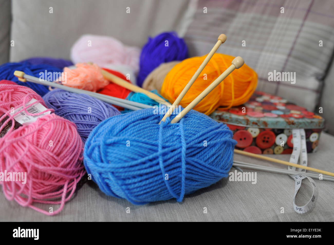 Maglia di lana e aghi sul divano Foto Stock