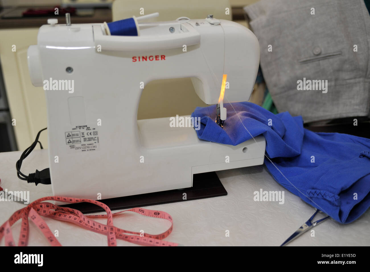 Riparazione dei vestiti con la macchina da cucire Foto Stock