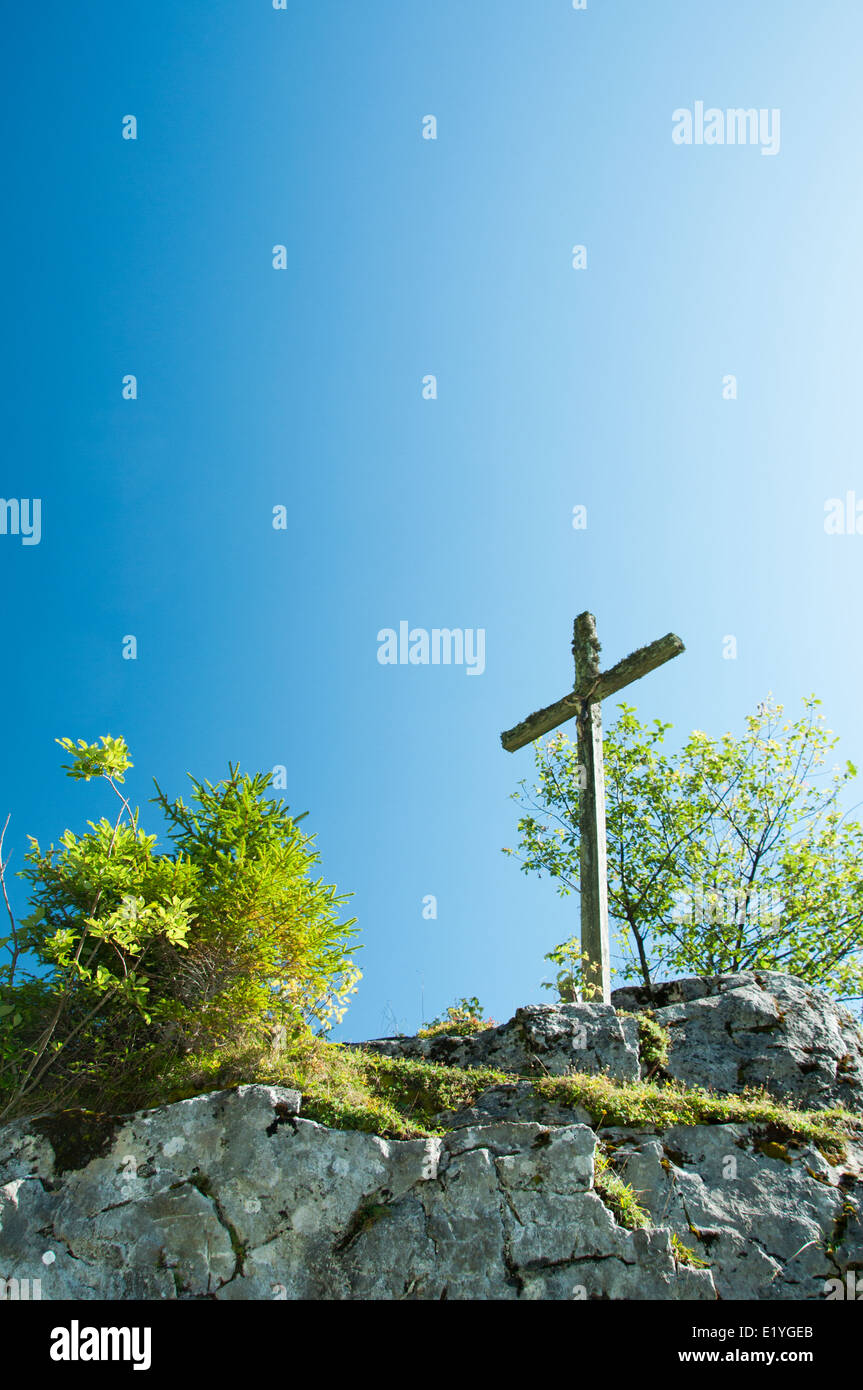Crocifisso nelle montagne contro il cielo blu Foto Stock