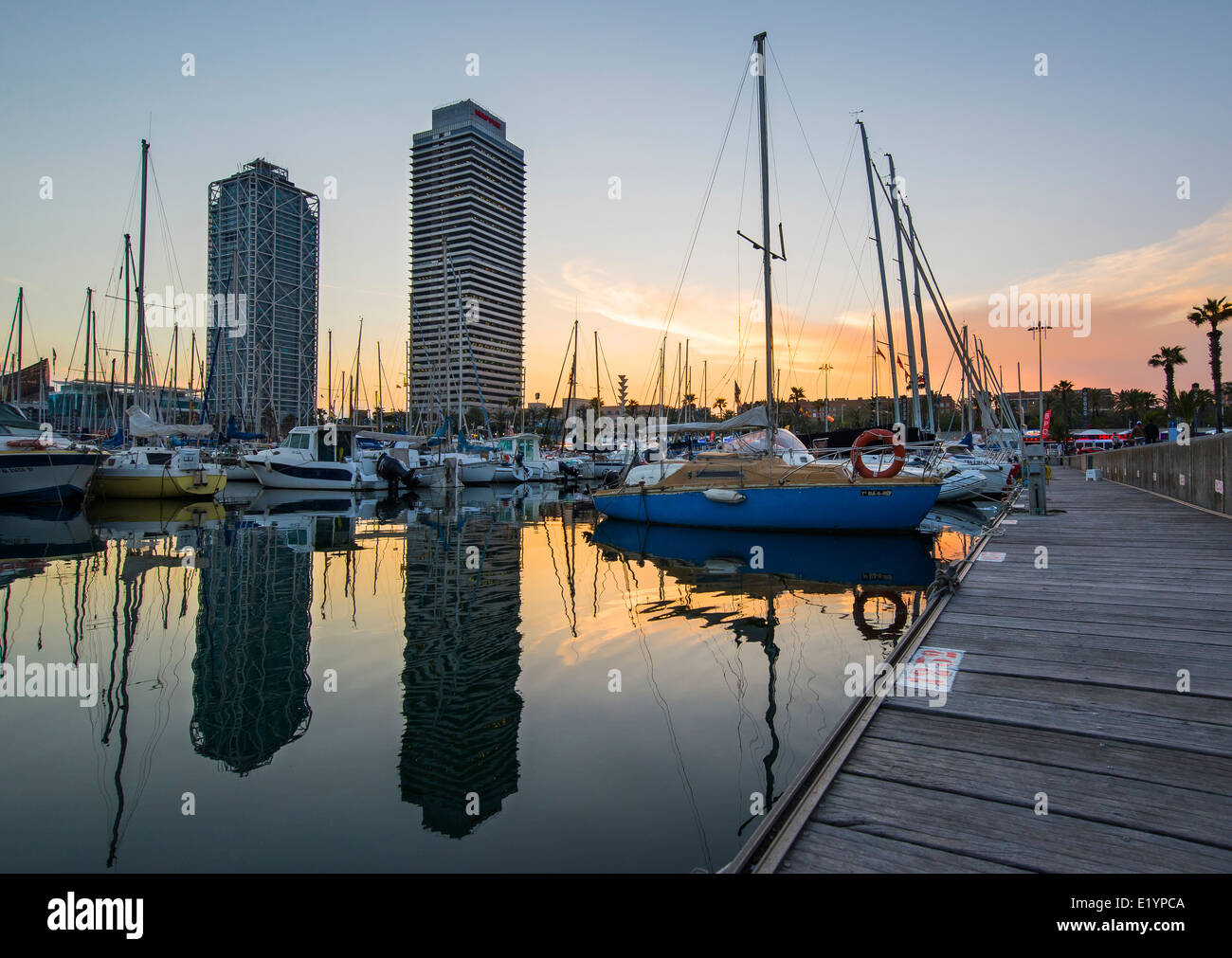 Skycrapers e barche in Barceloneta al tramonto. Foto Stock
