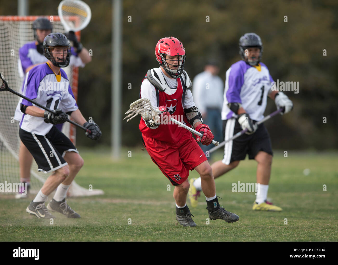 Alta scuola ragazzi indossare i caschi e di gareggiare in una gamma lacrosse corrispondono a Austin, Texas. Foto Stock