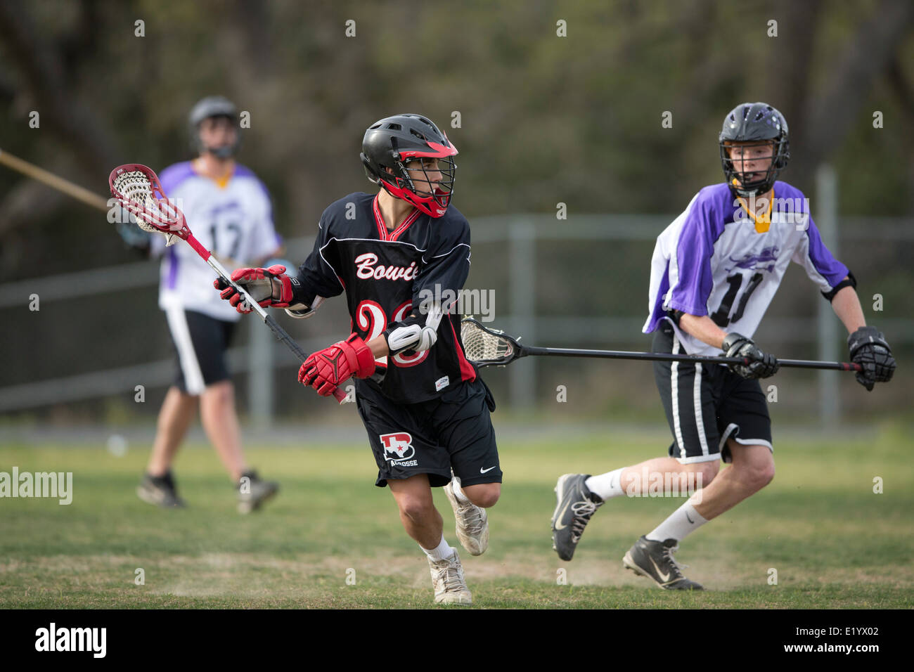 Alta scuola ragazzi indossare i caschi e di gareggiare in una gamma lacrosse corrispondono a Austin, Texas. Foto Stock