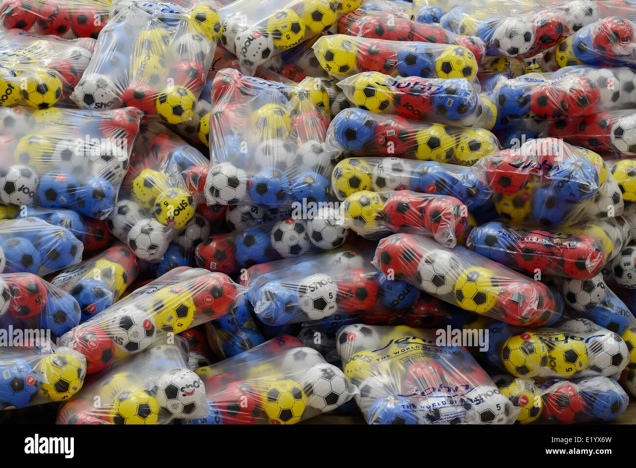 Grande pila di plastica a buon mercato multicolore di palloni da calcio Foto Stock