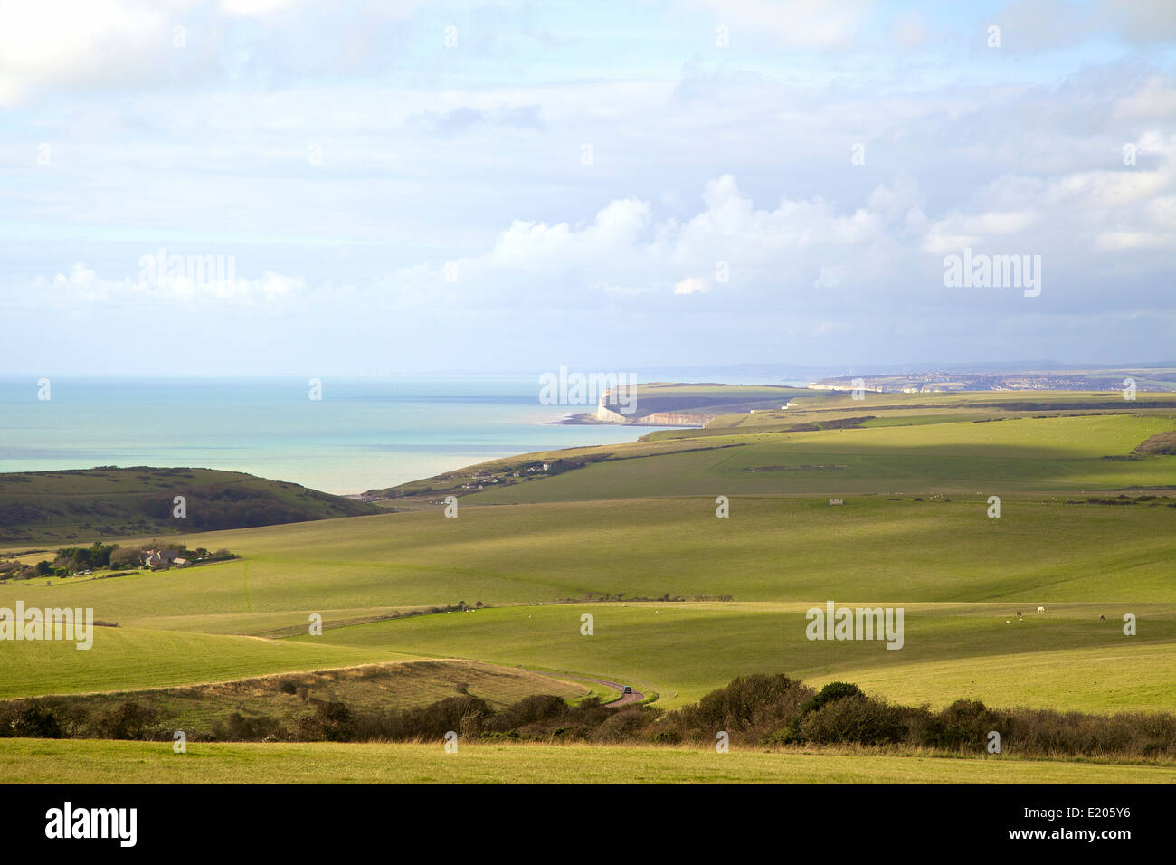 Guardando attraverso i campi sul South Downs modo verso le sette sorelle le scogliere su una tarda estate del giorno Foto Stock