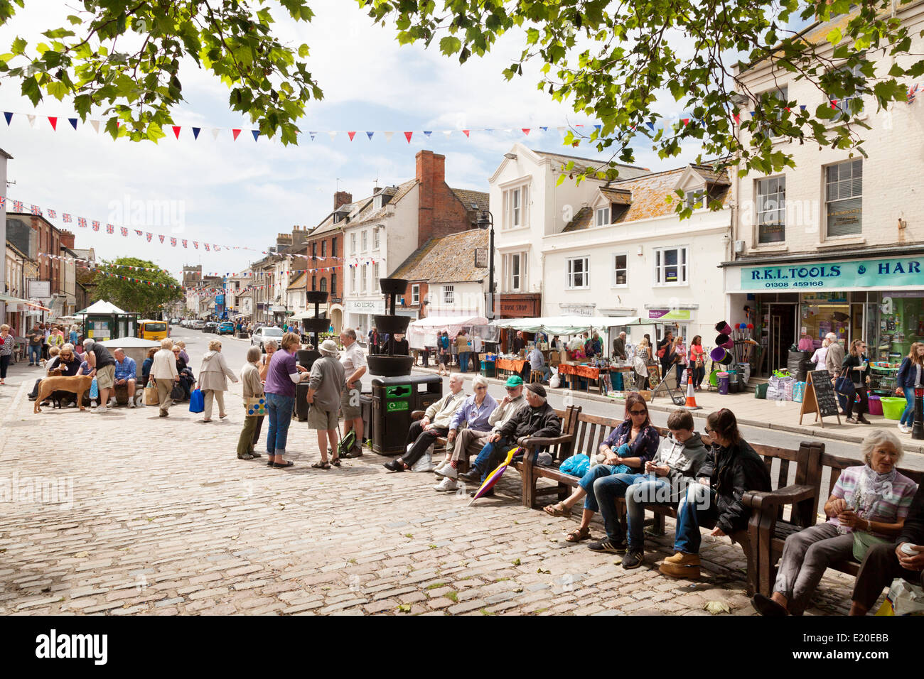 Centro città del Regno Unito, persone che si trovano nel centro della città in estate, Bridport, Dorset, Inghilterra Regno Unito Foto Stock