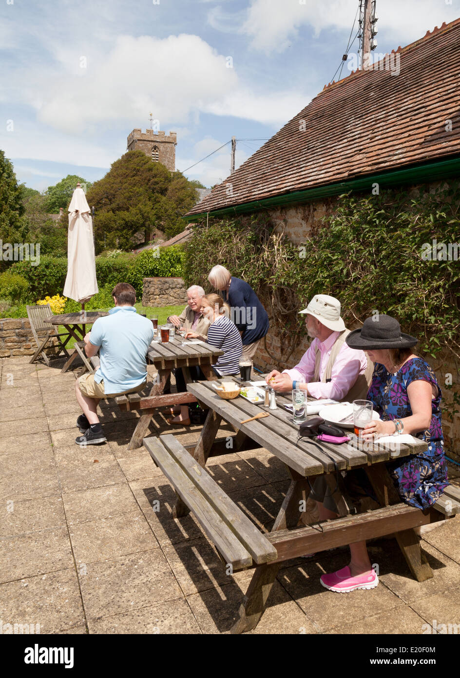 Persone bere e mangiare fuori a tre ferri di cavallo, pub Powerstock Village, vicino a Bridport, DORSET REGNO UNITO Foto Stock