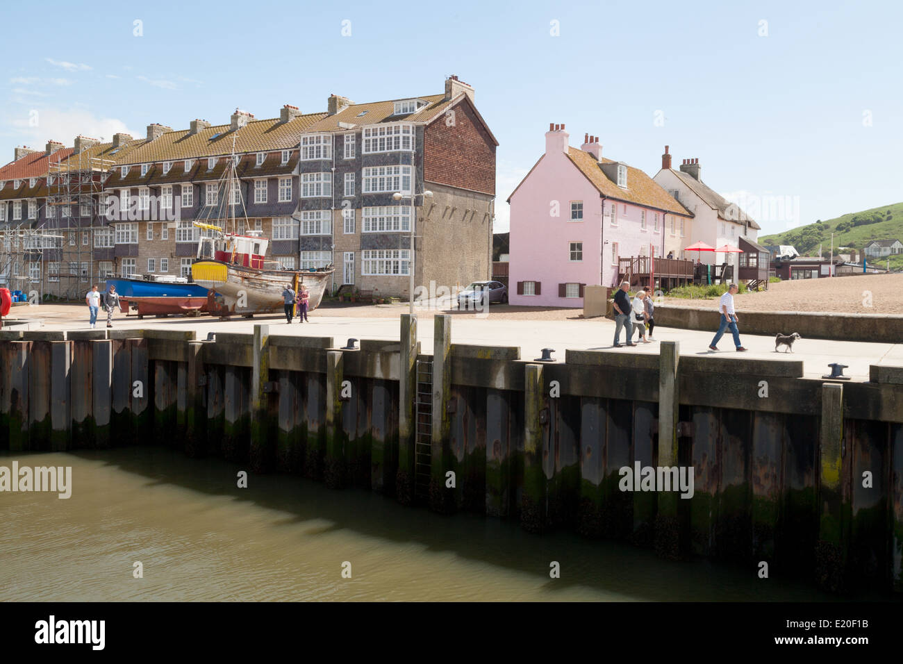 West Bay - edifici sul molo e gente che cammina, Bridport Harbour, Dorset percorso, DORSET REGNO UNITO Inghilterra Foto Stock