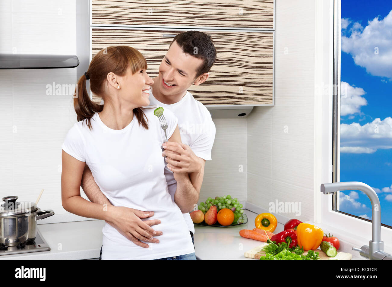 La felice coppia giovane abbraccia su cucina Foto Stock