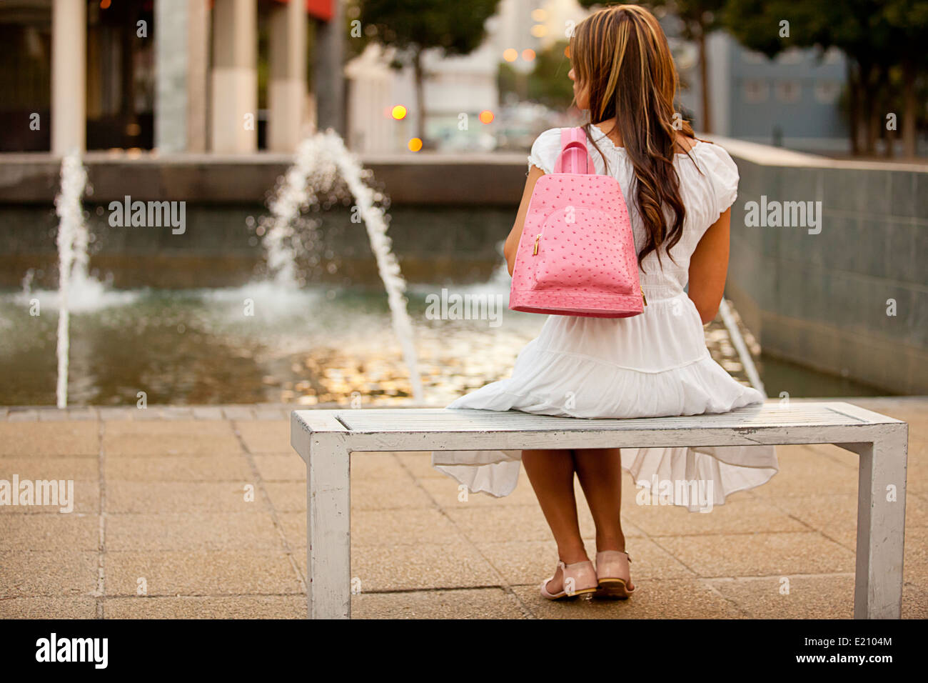 Signora femminile della modellazione di un rosa Zaino in pelle indossando blu denim shirt e mantello bianco Foto Stock