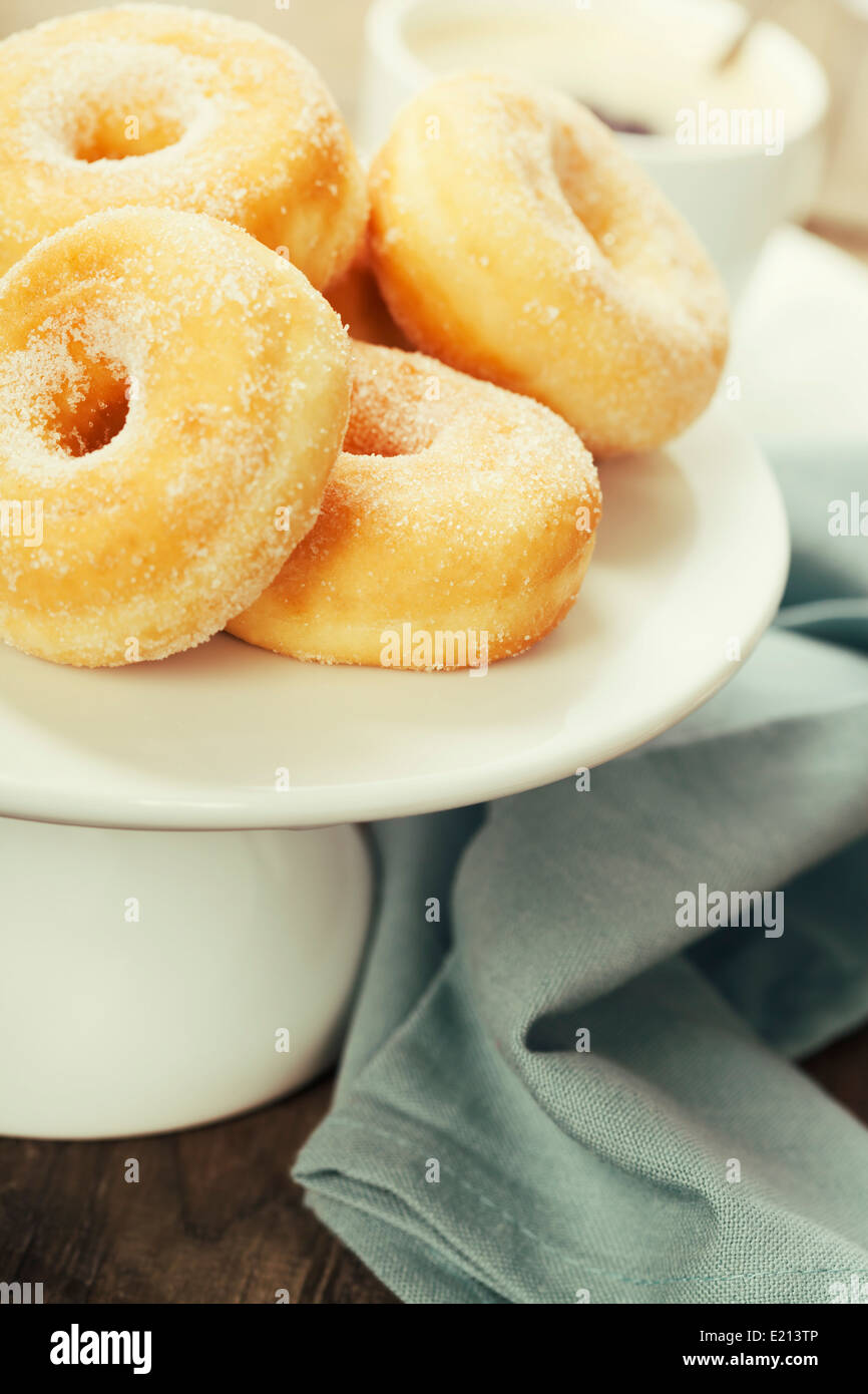 Pausa caffè fresco con ciambelle zuccherine su sfondo bianco Foto Stock