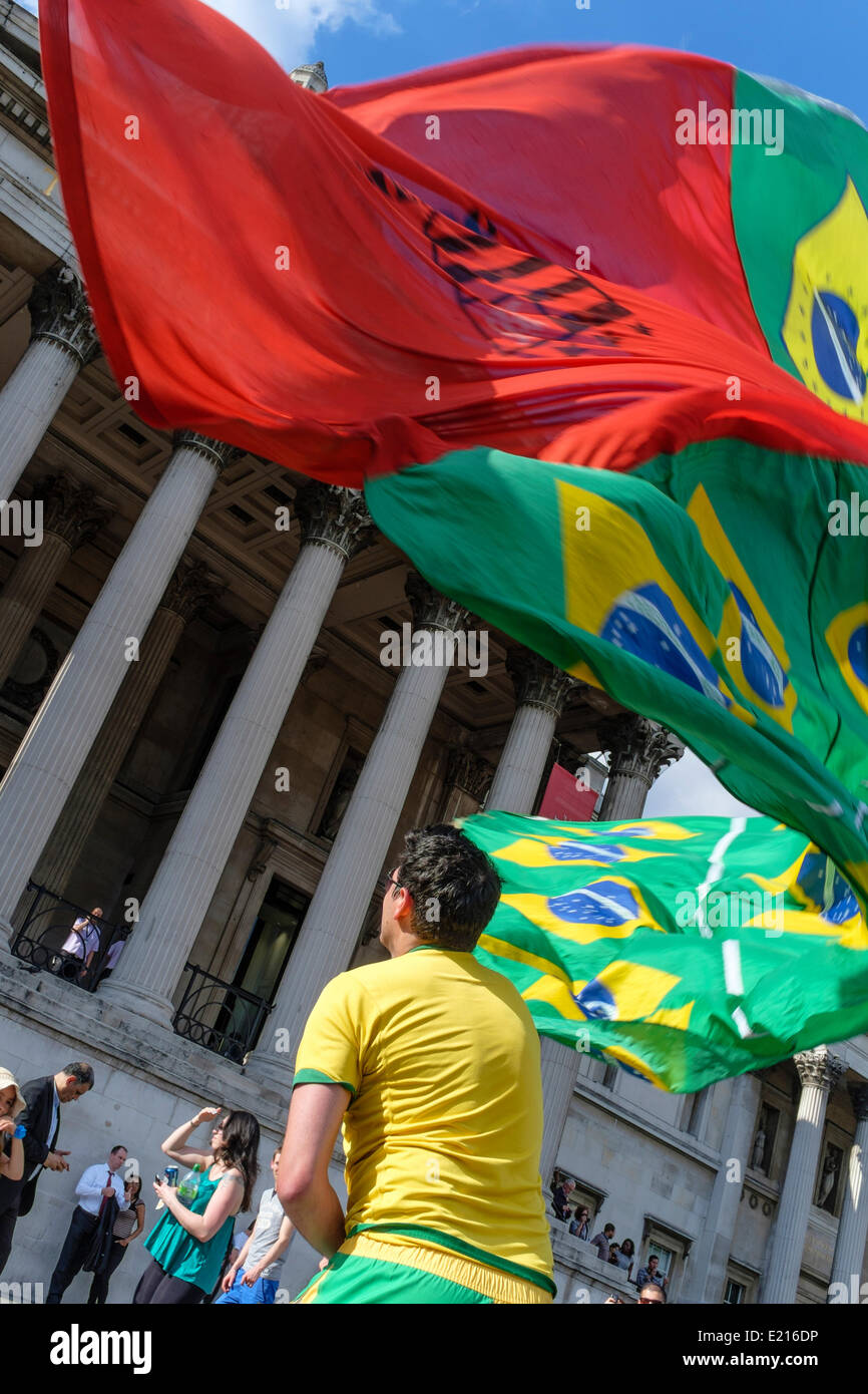 Un calcio brasiliano onde ventola una grande bandiera per festeggiare l'inizio della Coppa del Mondo 2014 in Brasile. Londra, Regno Unito Foto Stock