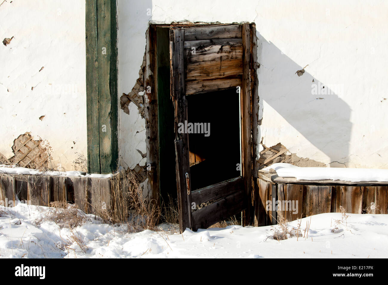 Coperta di neve house il degrado urbano rotto in legno della porta Foto Stock