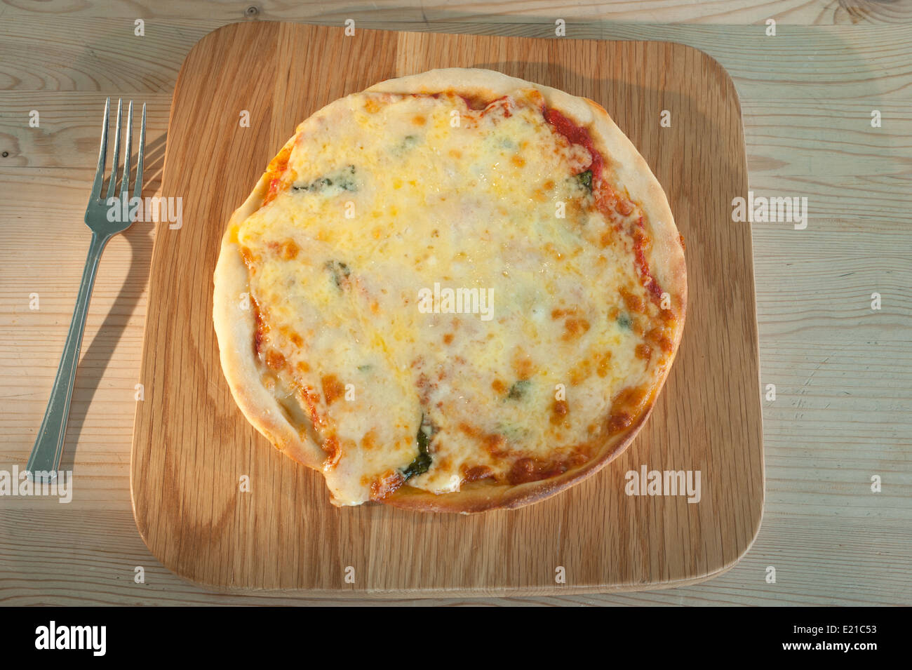 La pizza servita su un tagliere di legno. Margherita con pomodoro mozzarella e basilico. Foto Stock