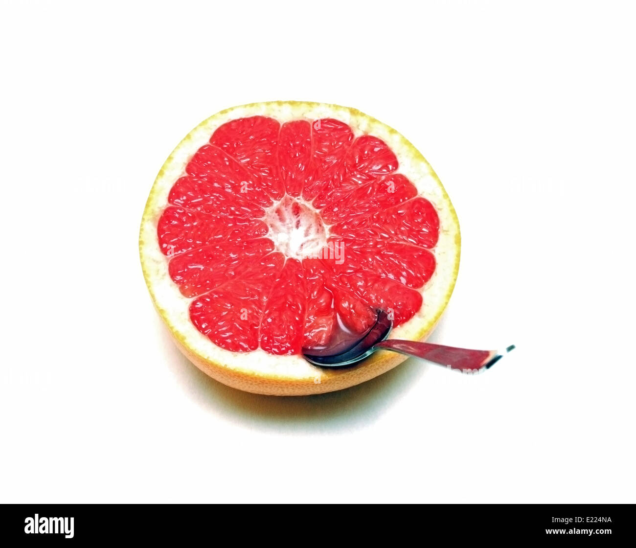 Una metà pompelmo con un cucchiaio Foto Stock