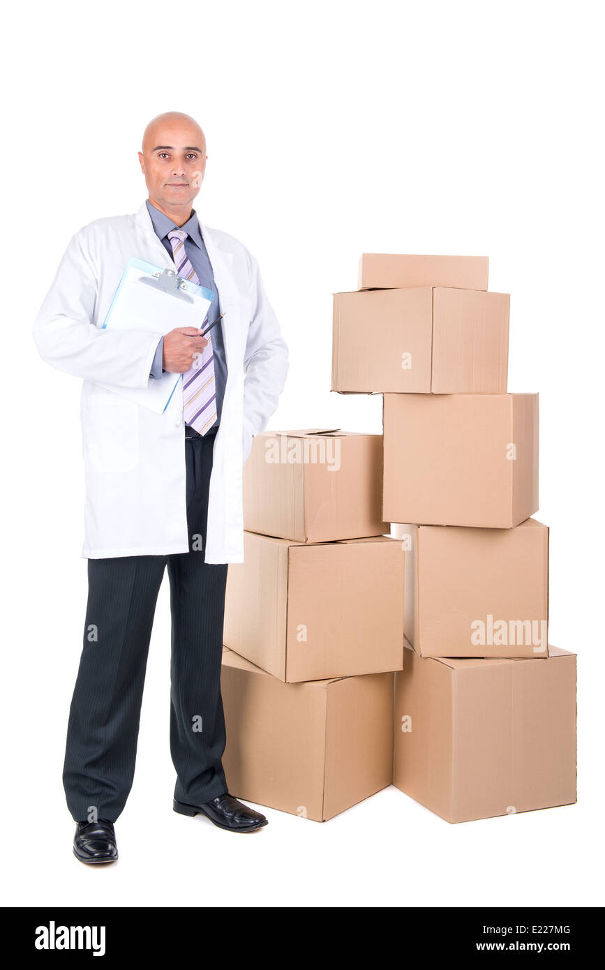 Imprenditore in posa in prossimità di una pila di scatole di cartone Foto Stock