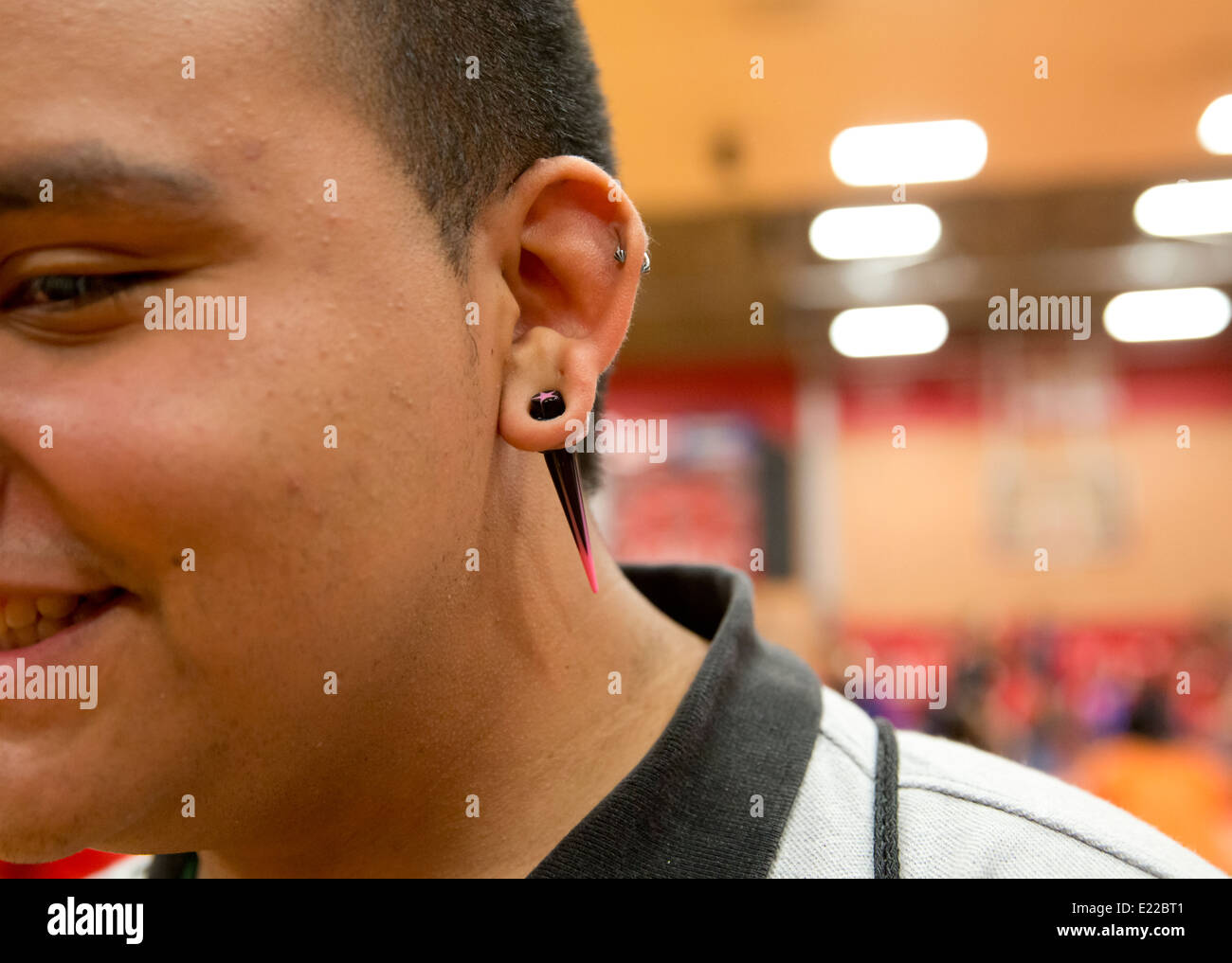 Ispanico high school senior studente maschio con un arpioncino orecchini Foto Stock