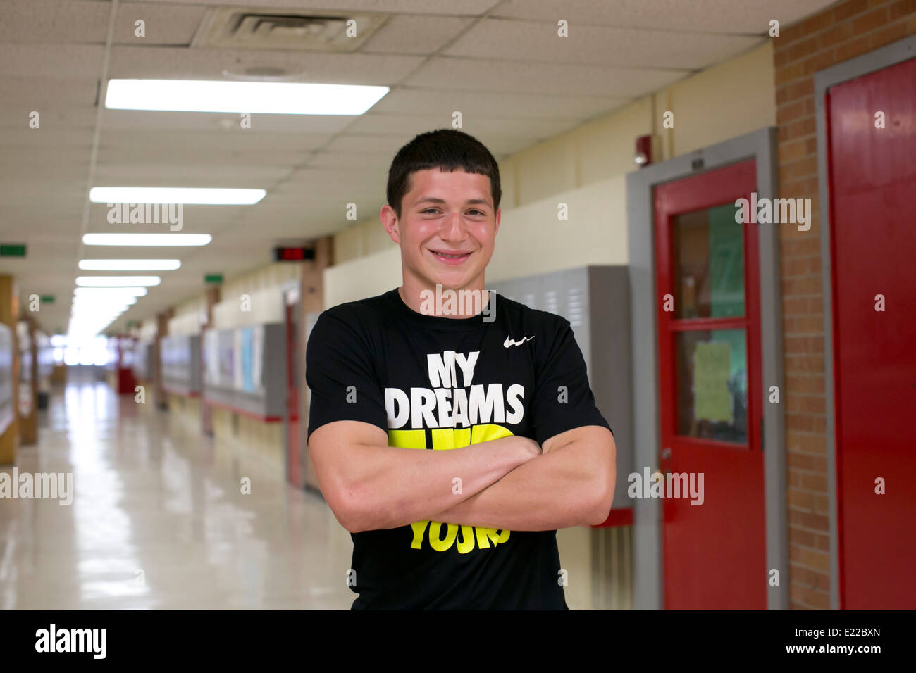 Maschio della high school senior atleta studente, pone nel corridoio della sua Austin, Texas school Foto Stock