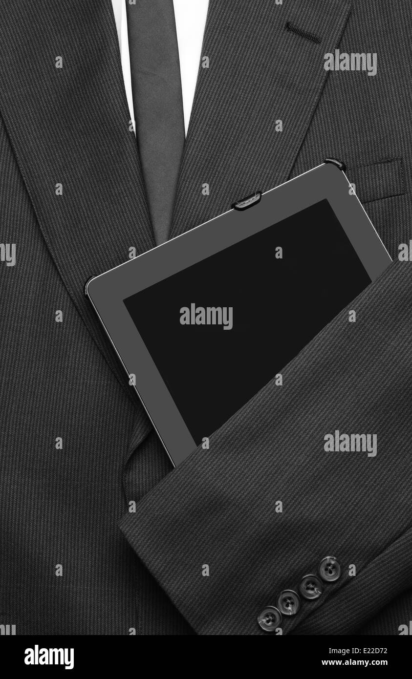 Primo piano di una camicia di business con una camicia bianca e cravatta con un braccio su un computer tablet. la tuta vuota è distesa e pronta Foto Stock