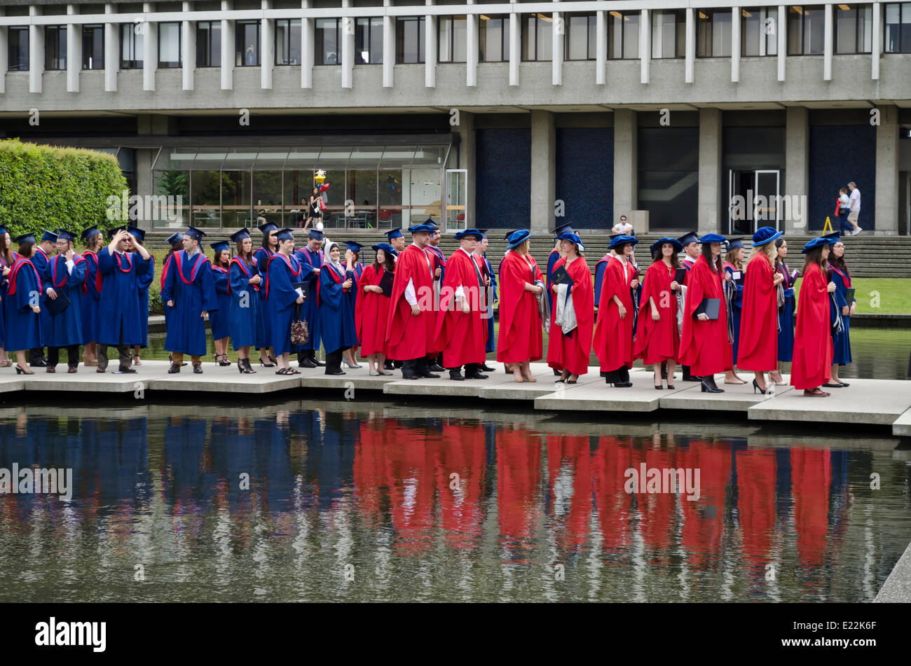 Simon Fraser University di lavoro Laureandi prima della primavera 2014 Convocazione cerimonia attendere da stagno in il quadrangolo accademico in Burnaby campus. Il rosso abiti sono indossati da dottorato di ricerca destinatari. Foto Stock