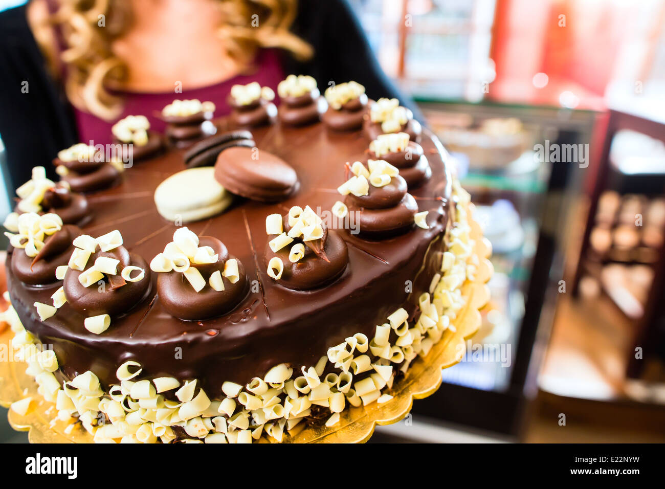 Pasticceria femmina presentando il vassoio della torta nel forno o pasticceria Foto Stock