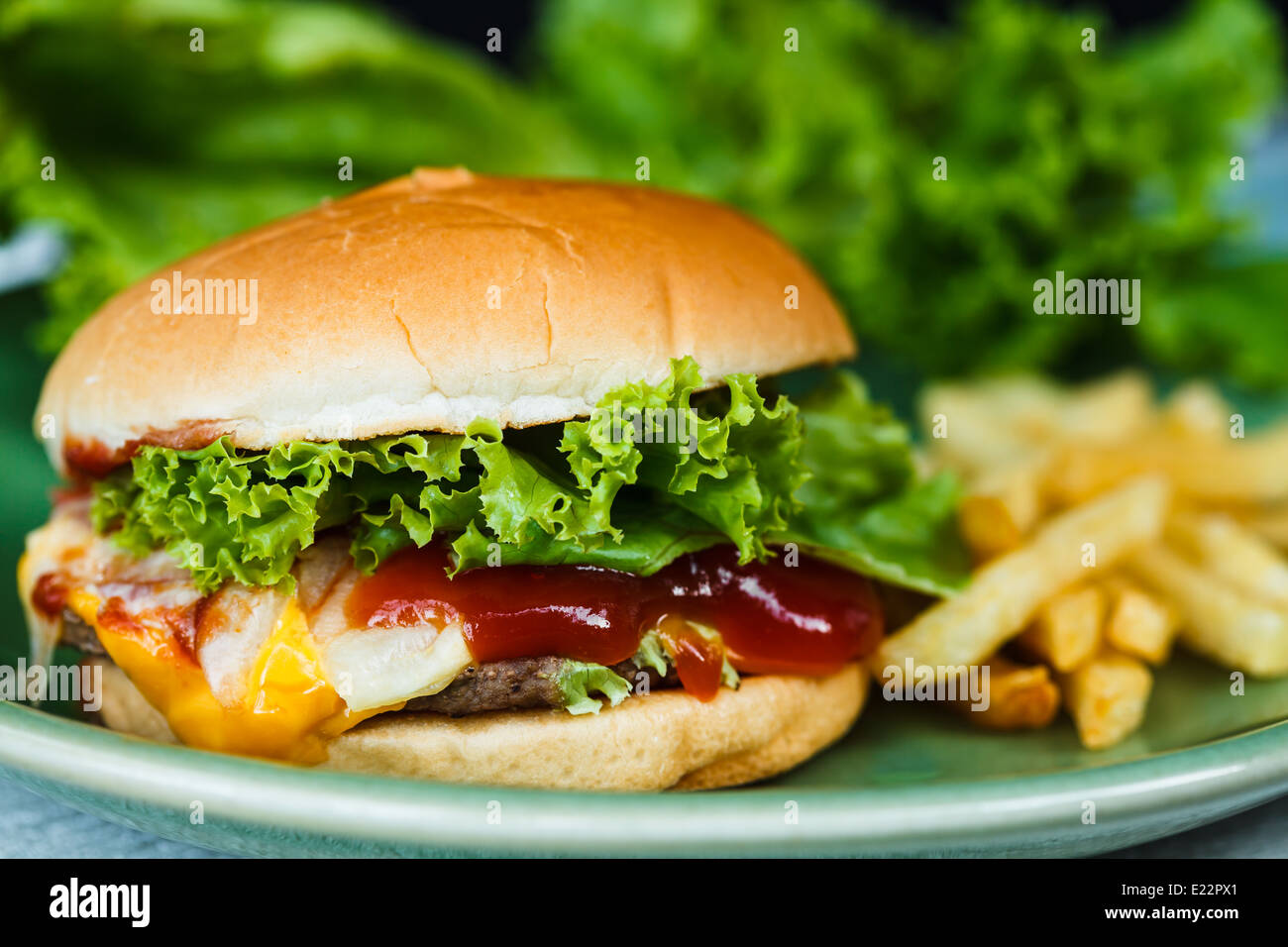 Cheeseburger, patatine fritte e verdura verde Foto Stock