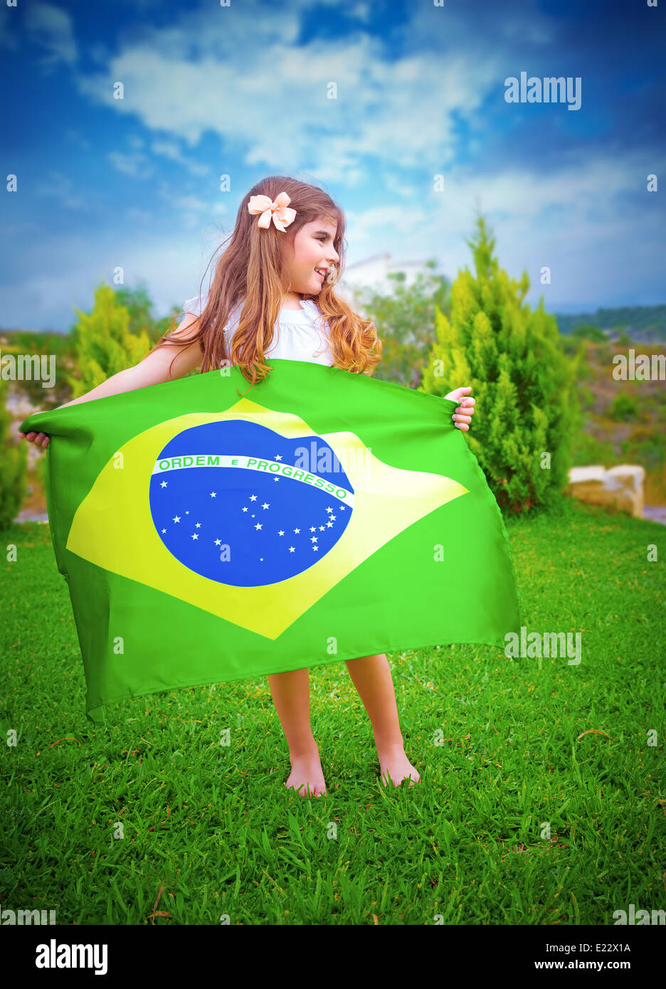 Il calcio brasiliano del team, ventola poco attraente ragazza tenendo in mani grandi Brasile bandiera nazionale, giocare all'aperto Foto Stock