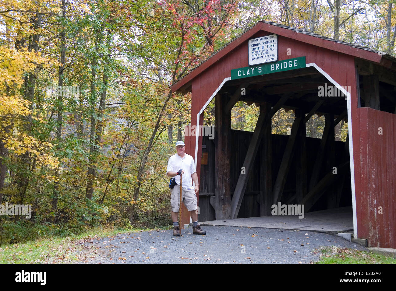 Escursionista presso Creta Bridge. Un ponte coperto in Perry County, Pennsylvania centrale circondata dalla caduta delle foglie. Foto Stock