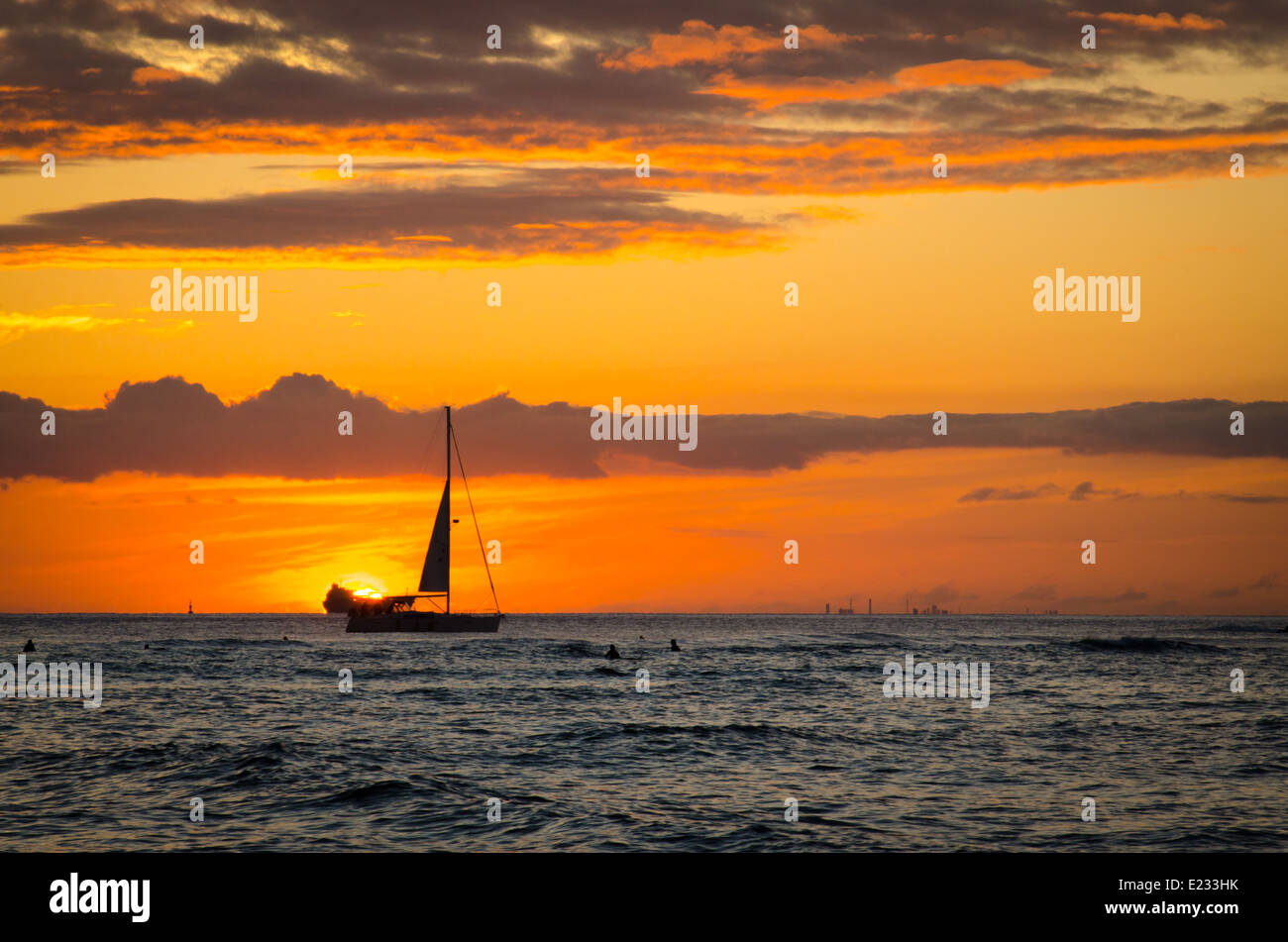 Barca profilarsi davanti al tramonto visto da Waikiki Beach in Hawaii Foto Stock