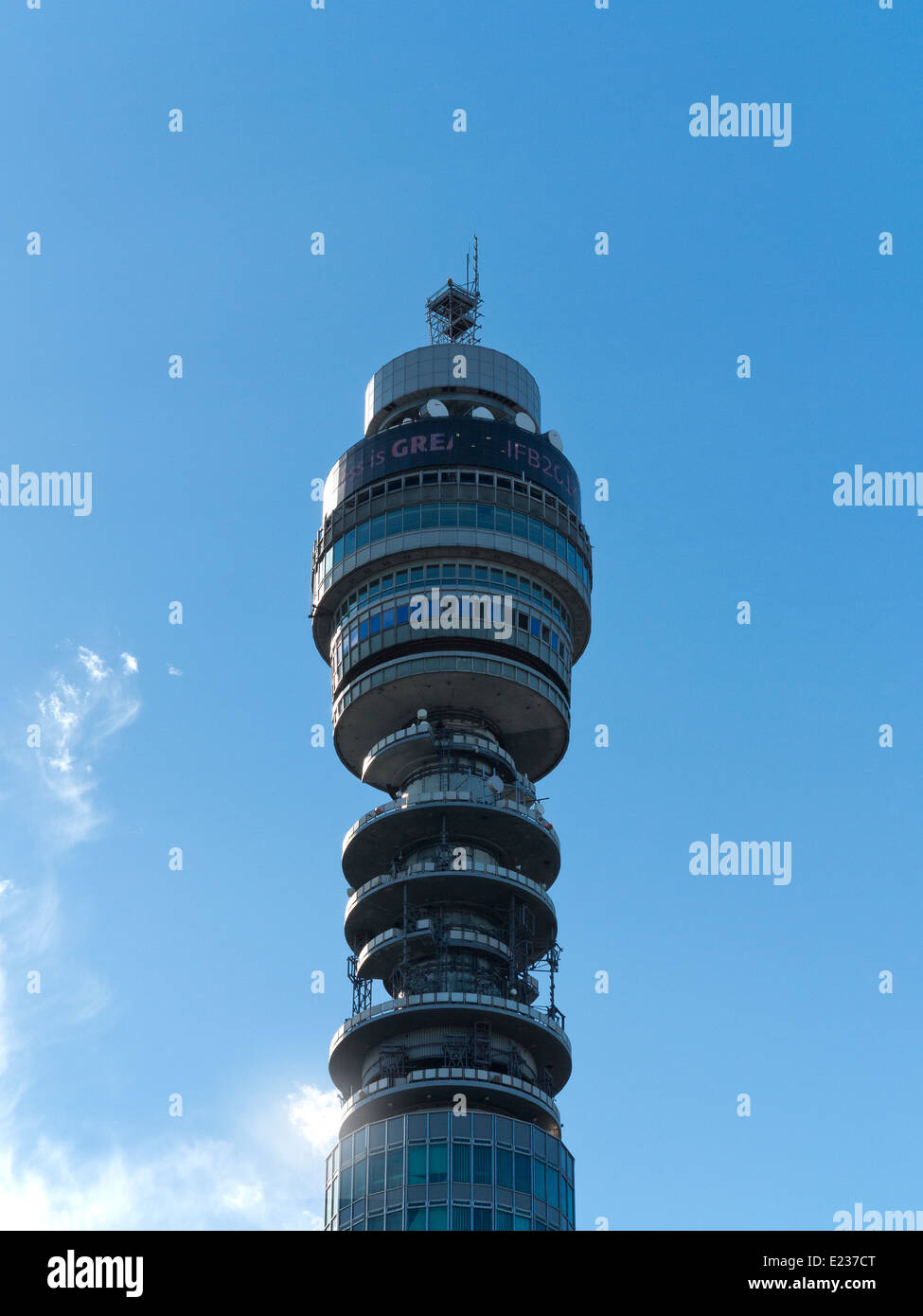 La sezione superiore della torre Telecom contro un cielo blu con nuvole bianche Foto Stock