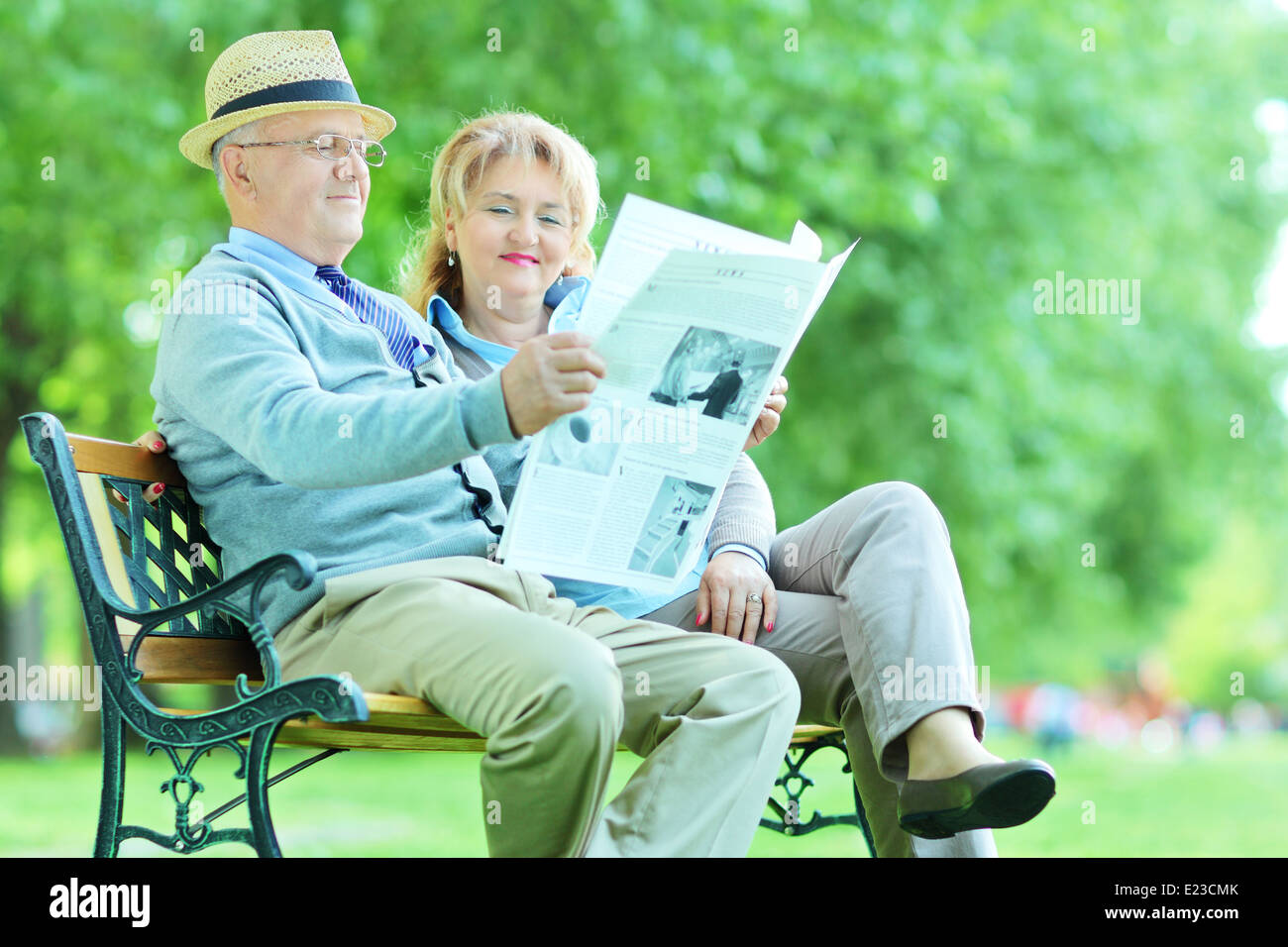 Uomo maturo e la donna la lettura di notizie all'esterno Foto Stock