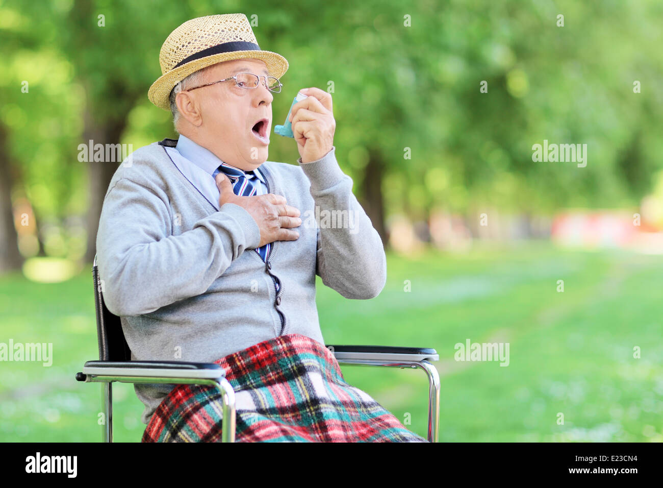 Senior uomo avente un attacco d' asma in un parco Foto Stock