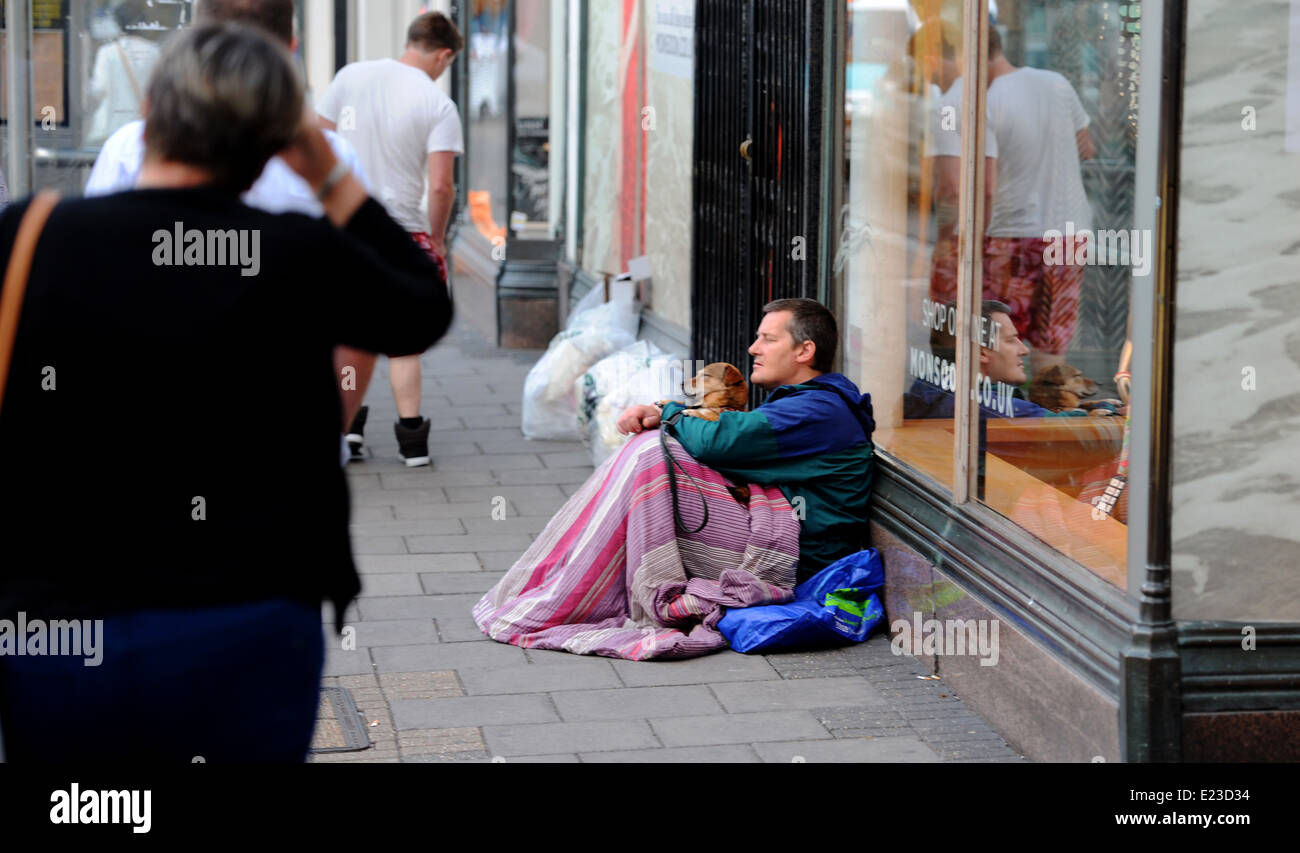 L'uomo sonno agitato per le strade di Brighton con il suo cane la sera come la gente a piedi passato Foto Stock