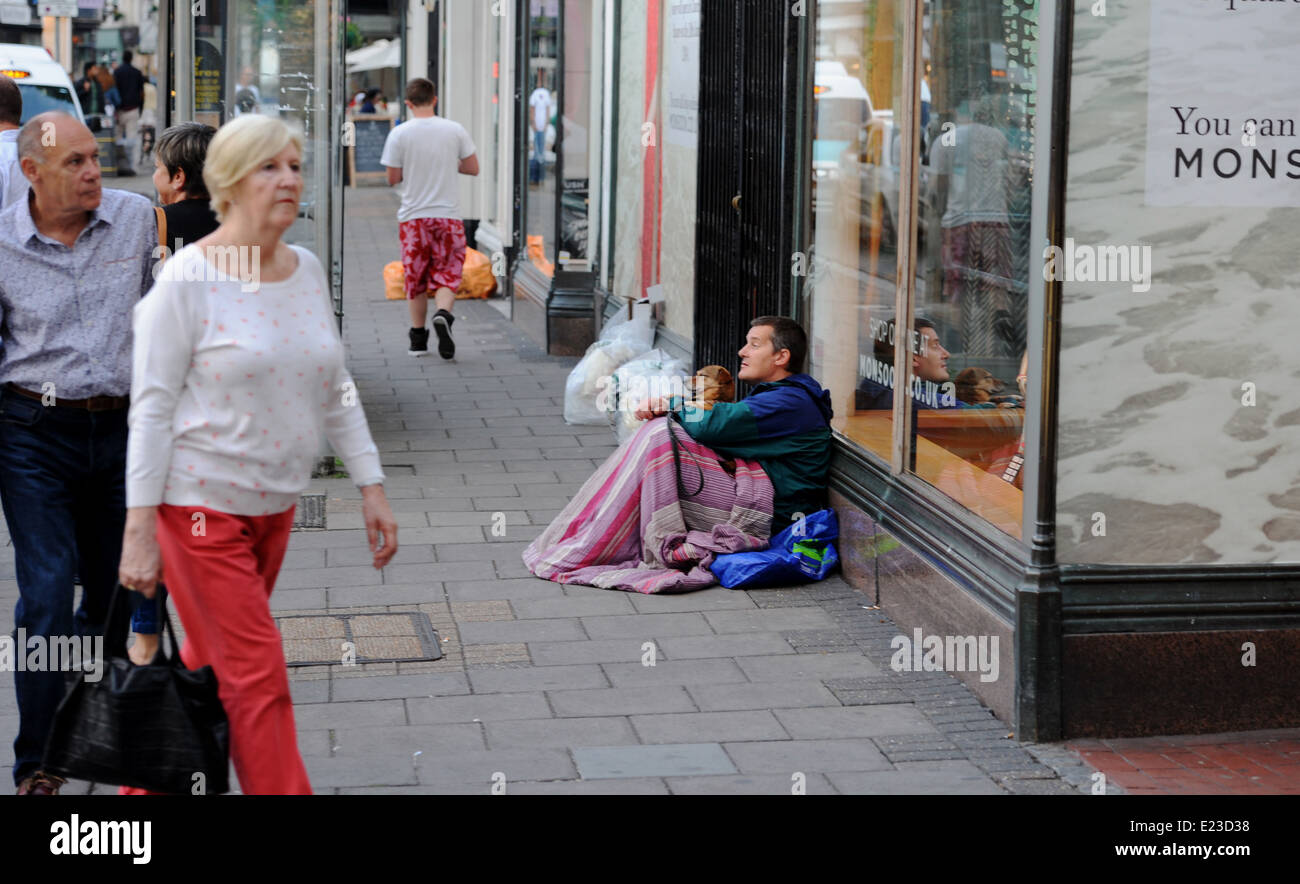 L'uomo sonno agitato per le strade di Brighton con il suo cane la sera come la gente a piedi passato Foto Stock