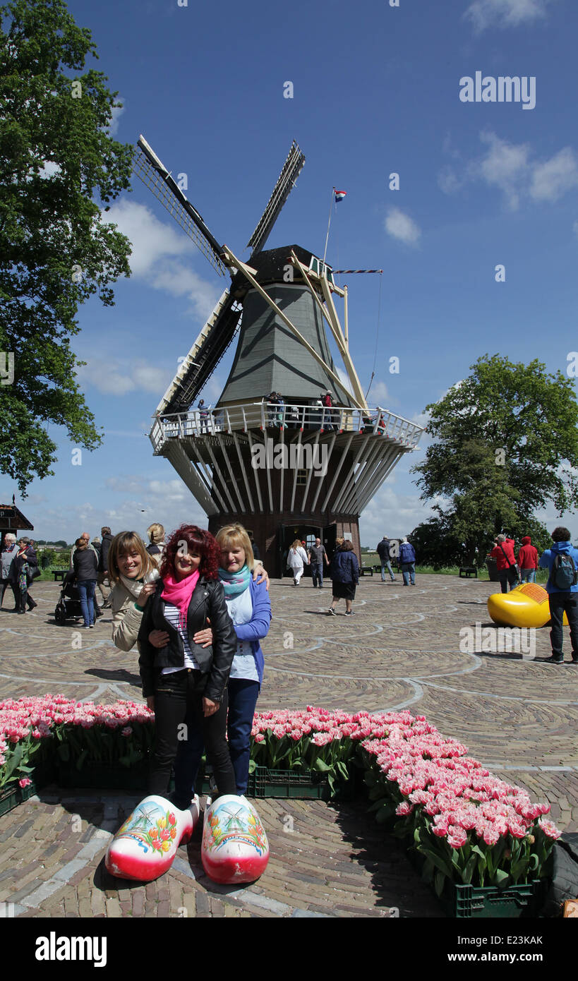 Un mulino a vento a Keukenhof nei Paesi Bassi.turisti in zoccoli che posano per una fotocamera.scarpe di legno. Foto Stock